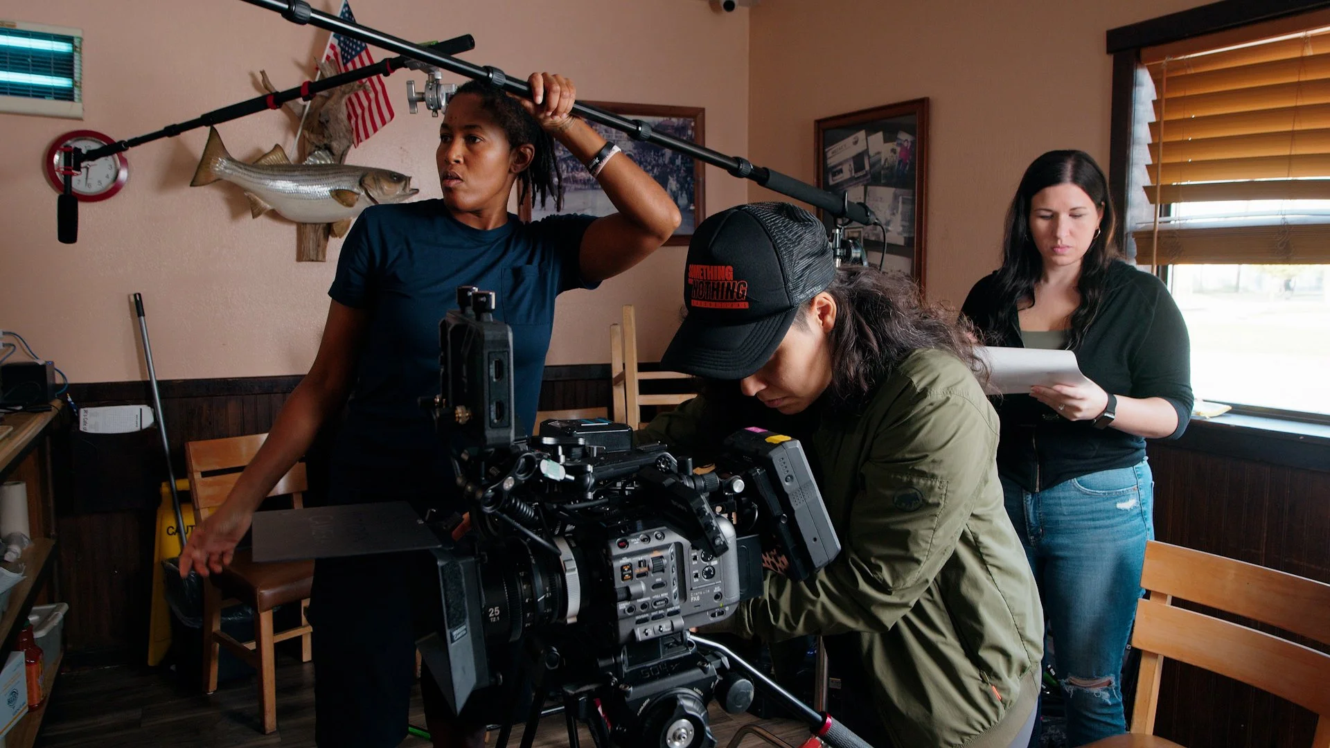 Filmmaking scene with three women preparing to shoot a documentary inside a small restaurant or café in fort worth texas. video production.