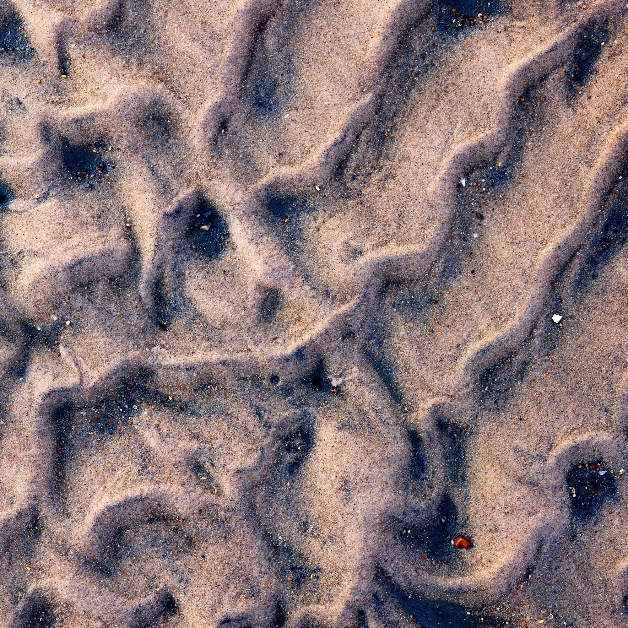Abstract close-up of sand texture showing flowing lines and wind-shaped surface patterns.