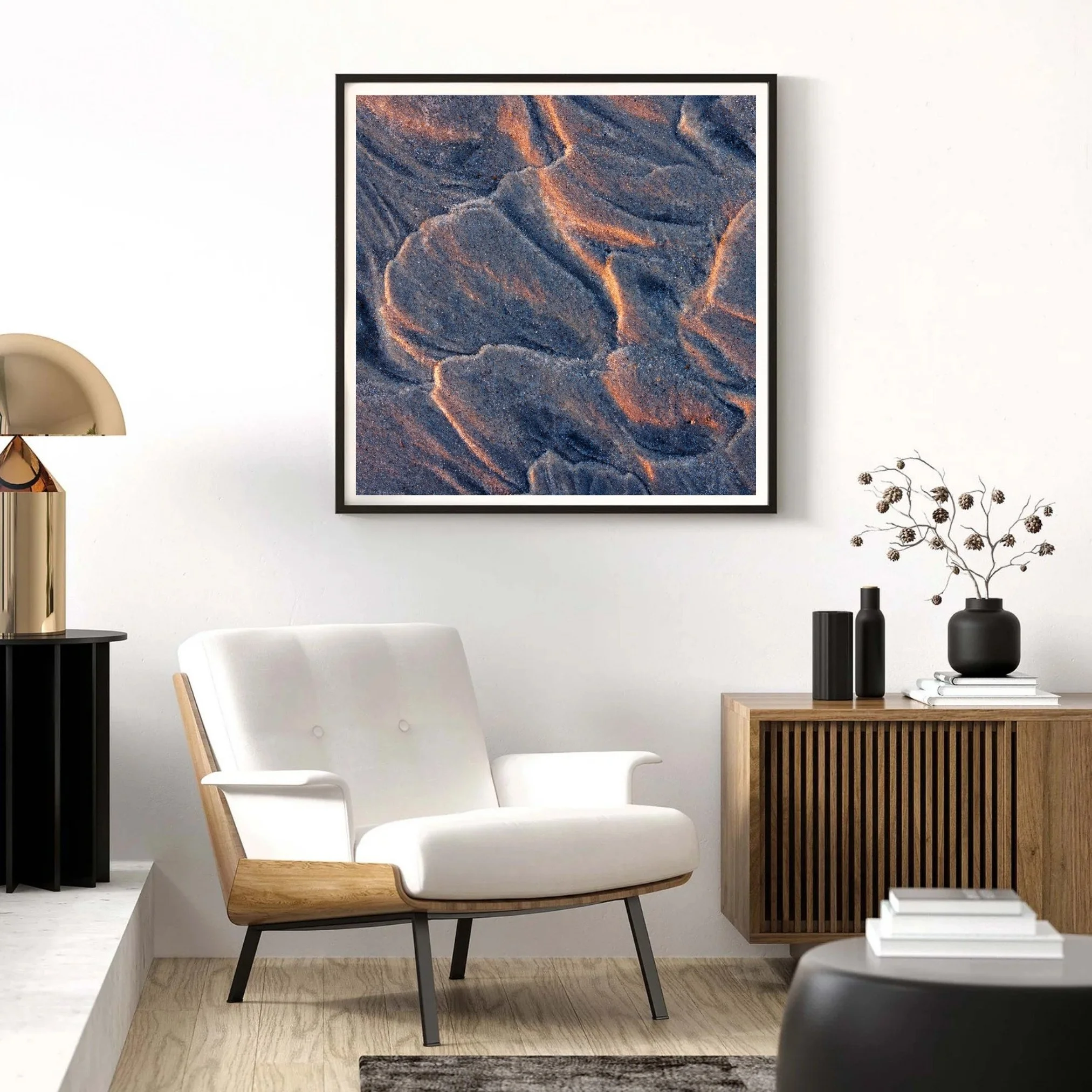 Framed photo of a sand texture printed on fine art paper sitting above a sitting area.
