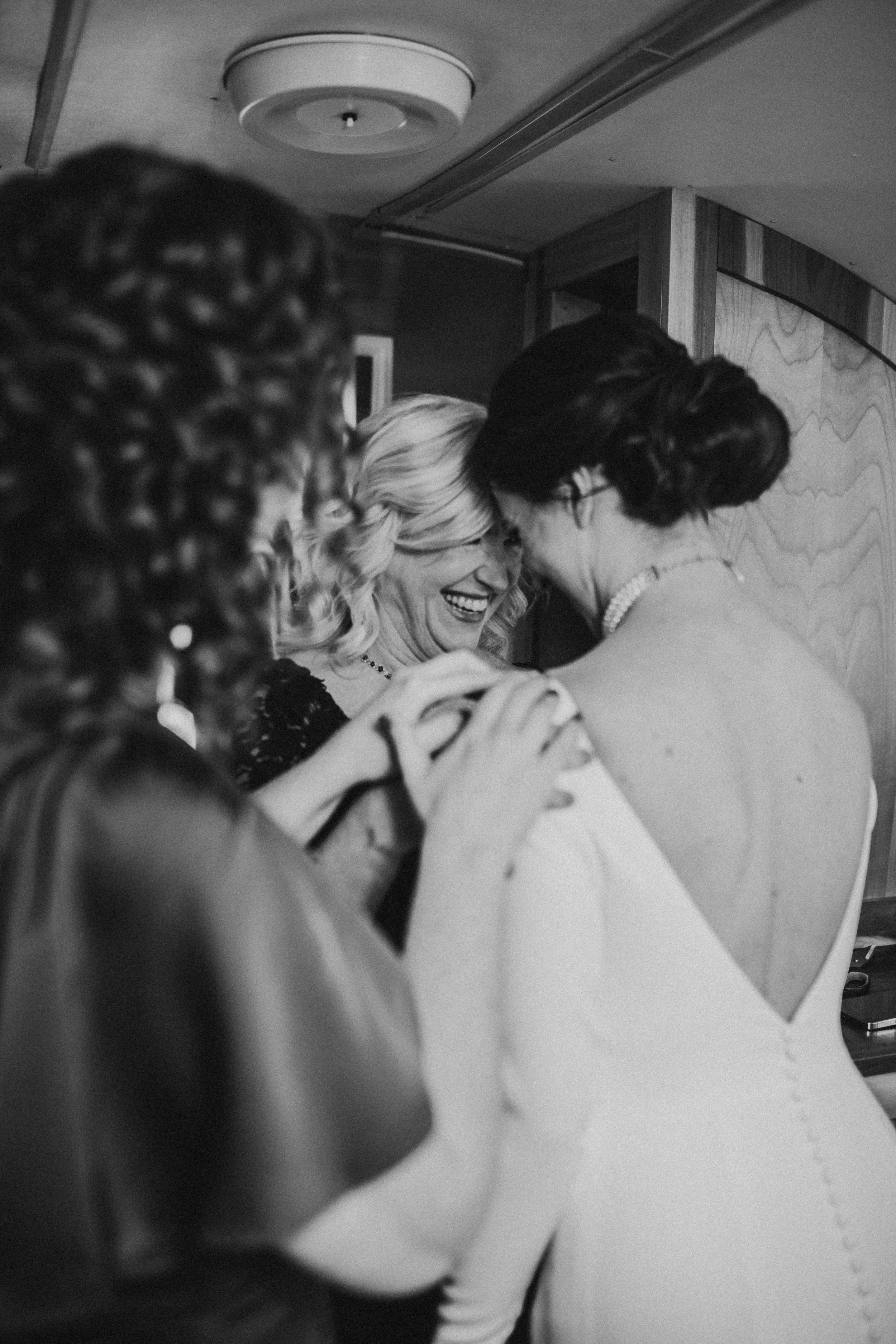 Several women sharing a joyful moment, with some smiling and embracing each other.
