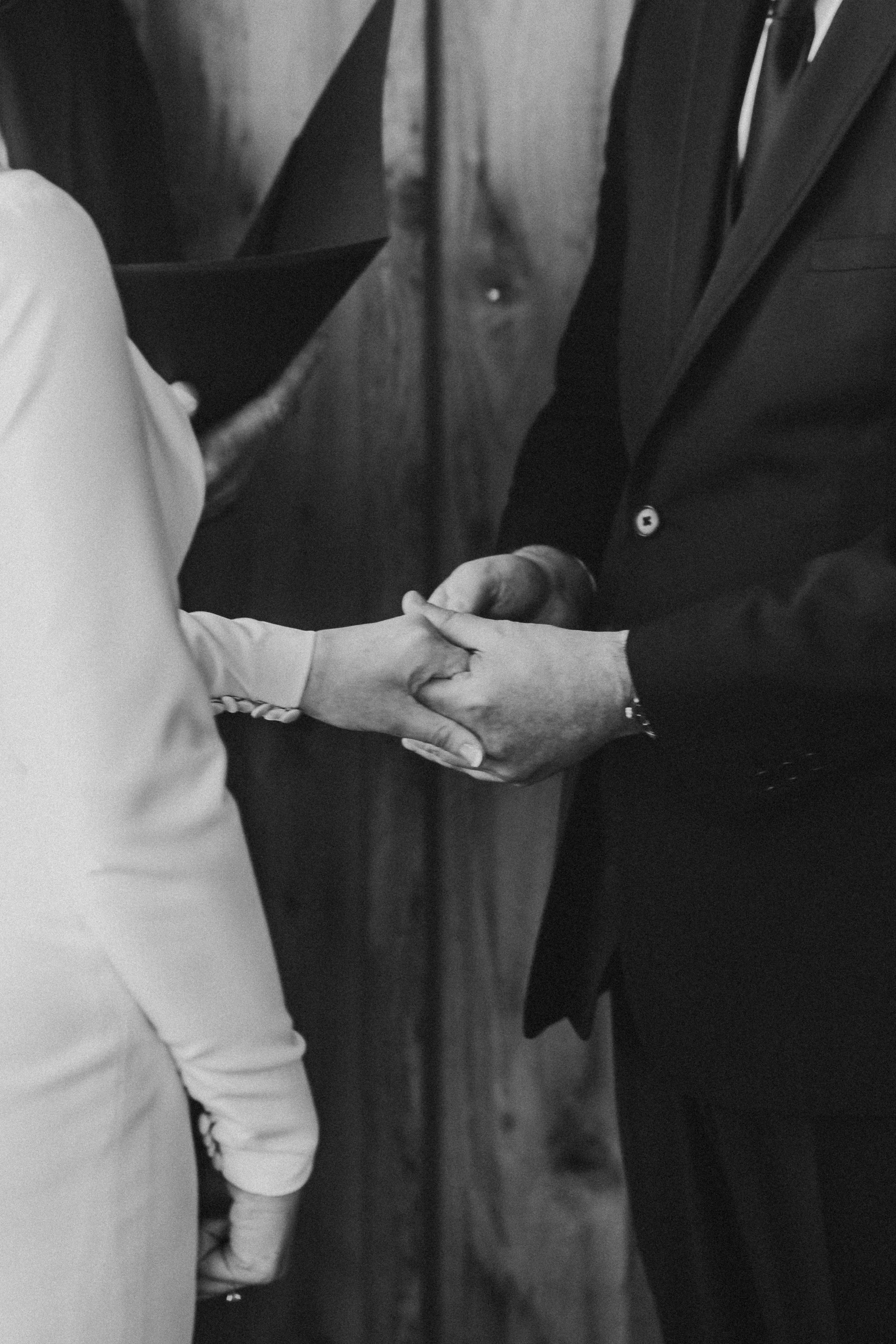 A man and a woman holding hands during a wedding ceremony.