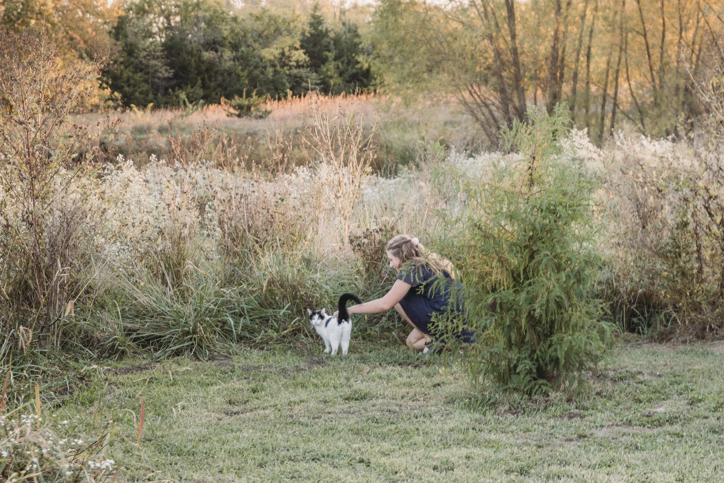 girl petting a cat at Burning Barrel LeCompton
