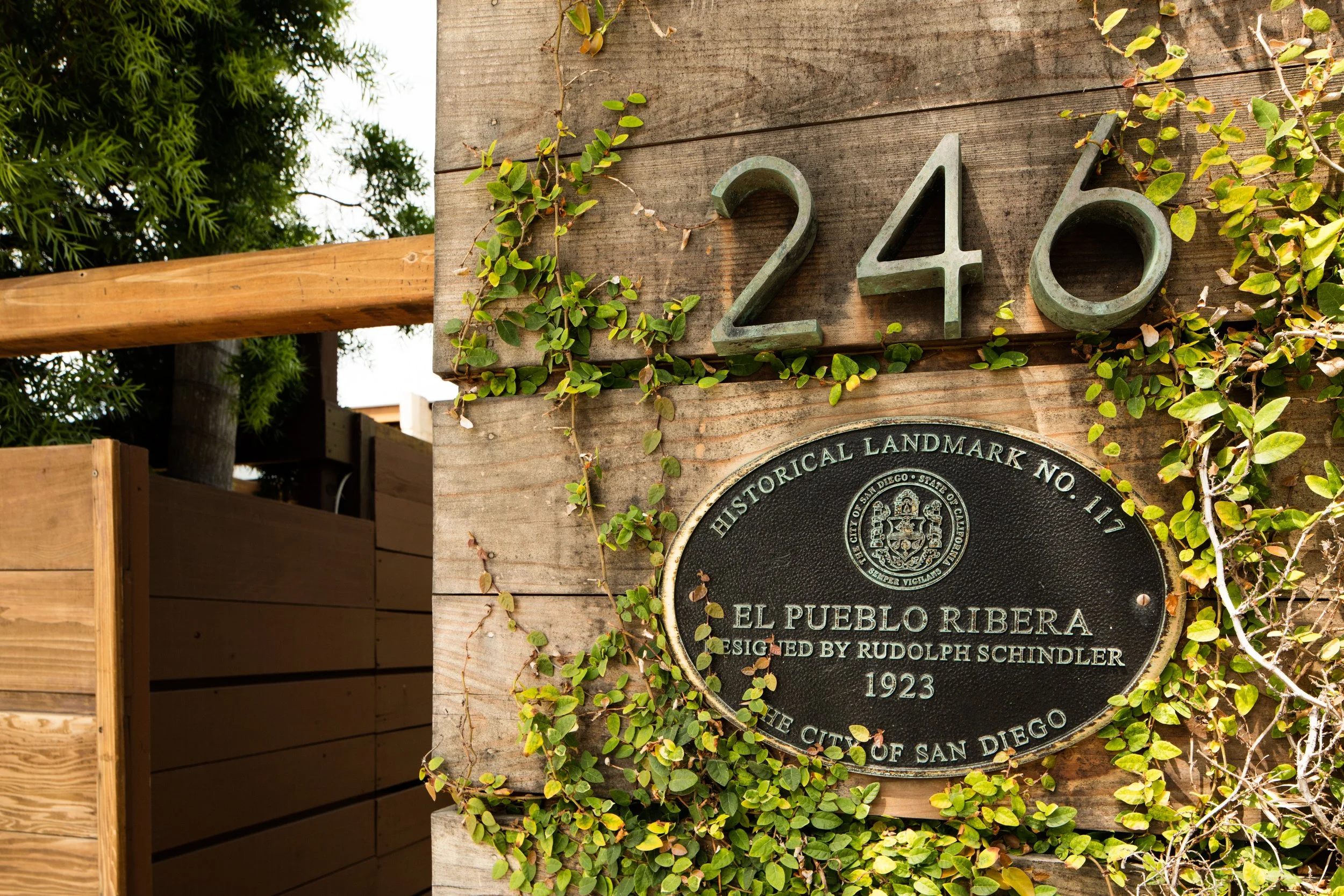 El Pueblo Ribera historic landmark plaque, No. 17, on a vine-covered wooden building in San Diego