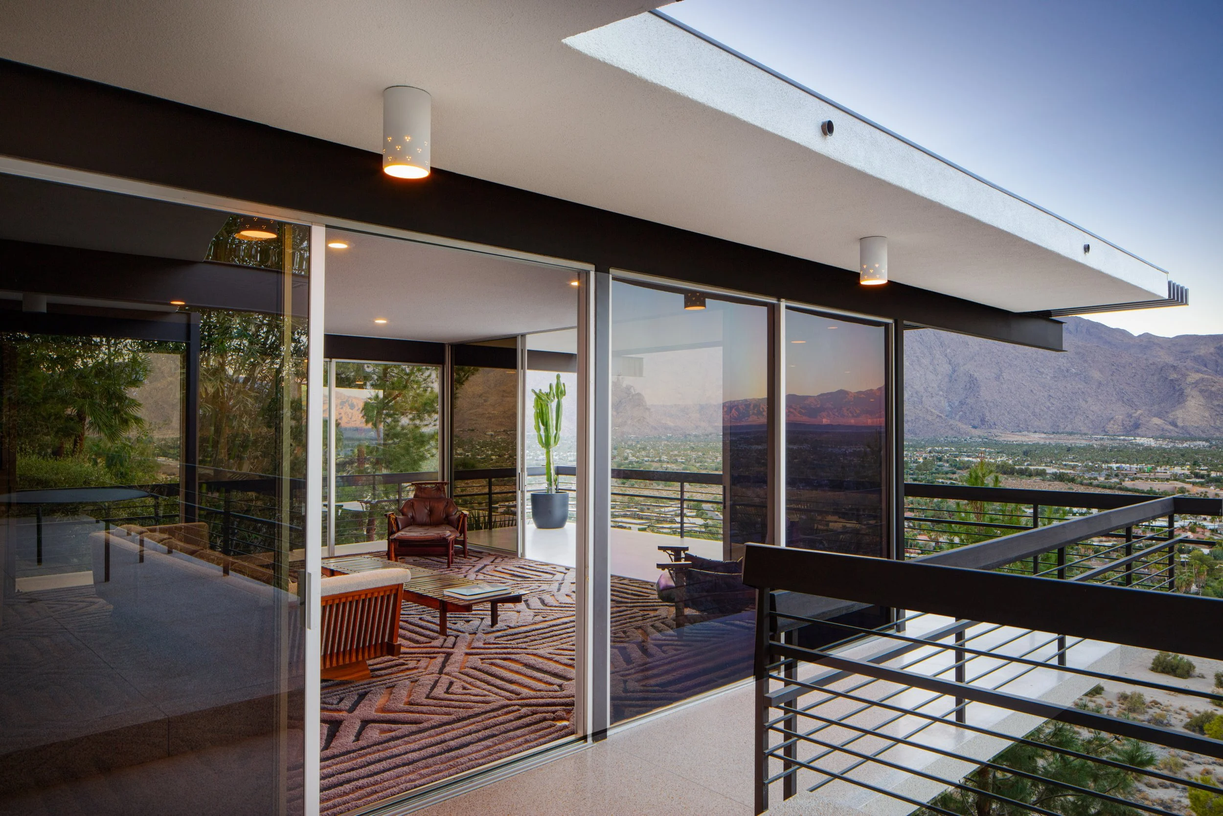 Modern glass-walled desert home with mountain and valley views