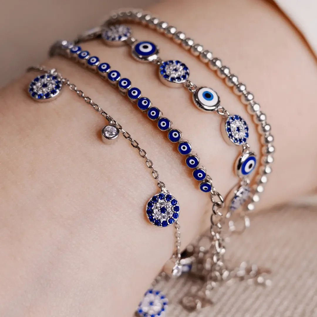 How to style evil eye jewelry - woman wearing evil eye bracelet stack and earrings