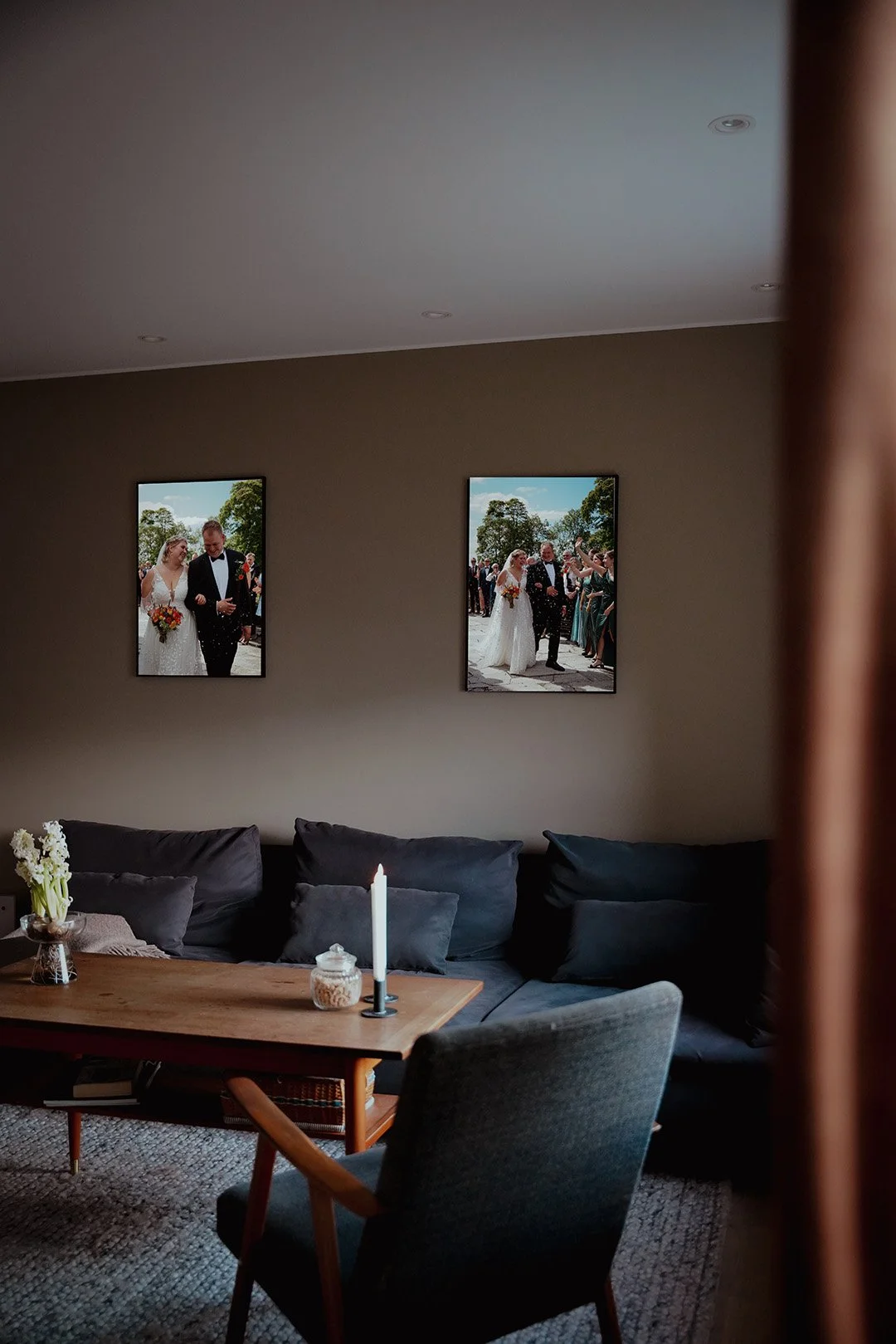 Nærbilde av en brud som holder en stor, hvit blomsterbukett med roser og peoner, mens hun står ved siden av en person i sølvfarget dress.