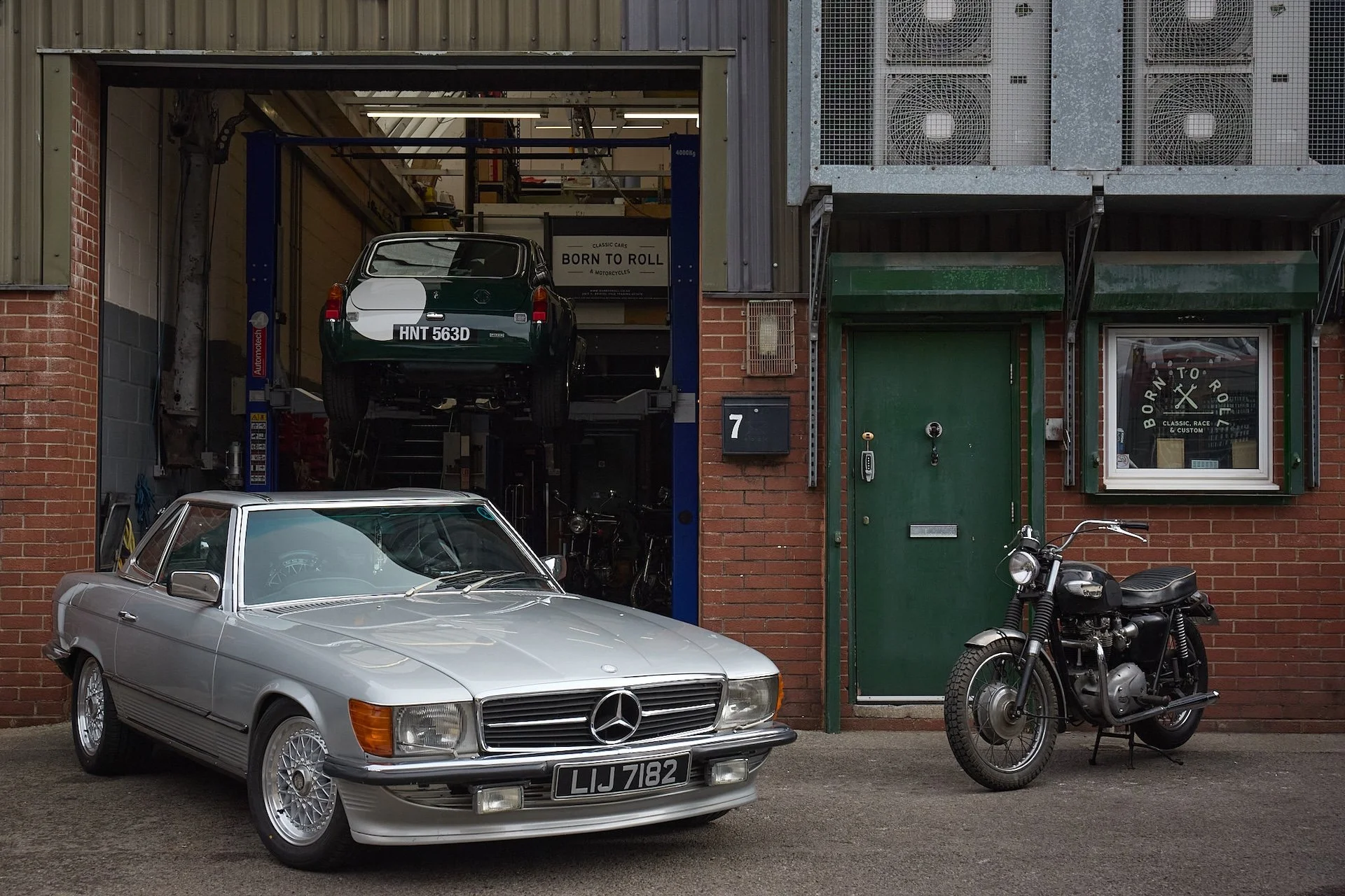 classic cars and motorcycles outside workshop in Bristol