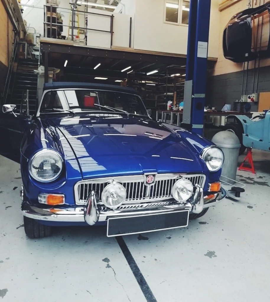 a blue classic MGB in a workshop