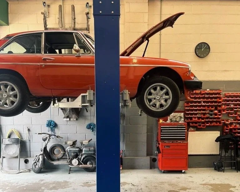 red mgb gt v8 engine being repaired in bristol workshop