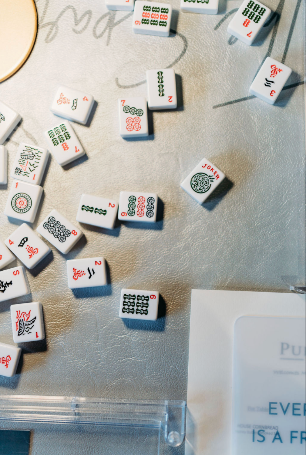 Close-up of a table with scattered Mahjong tiles at a Sparrow Social Society event in Huntsville.