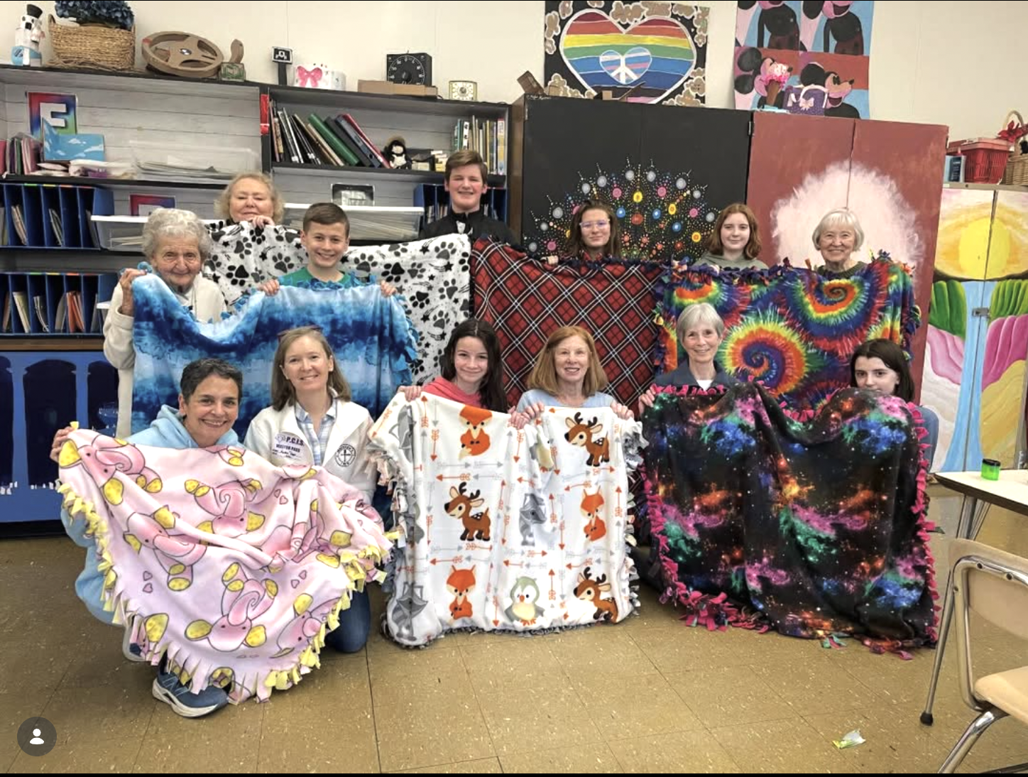 Image of people holding up handmade blankets