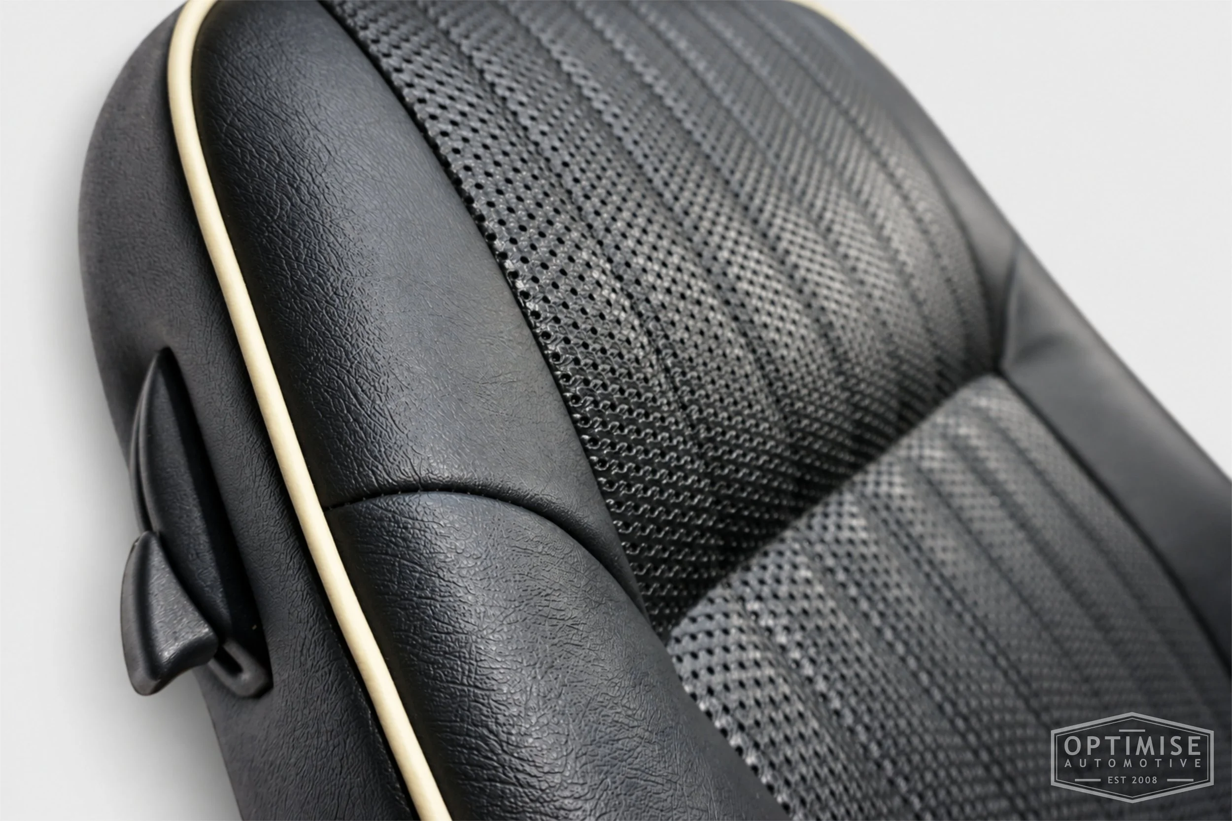 Classic Mini seat retrims featuring original MPi front seats and a matching rear seat, trimmed in black leatherette and black basketweave with cream piping.