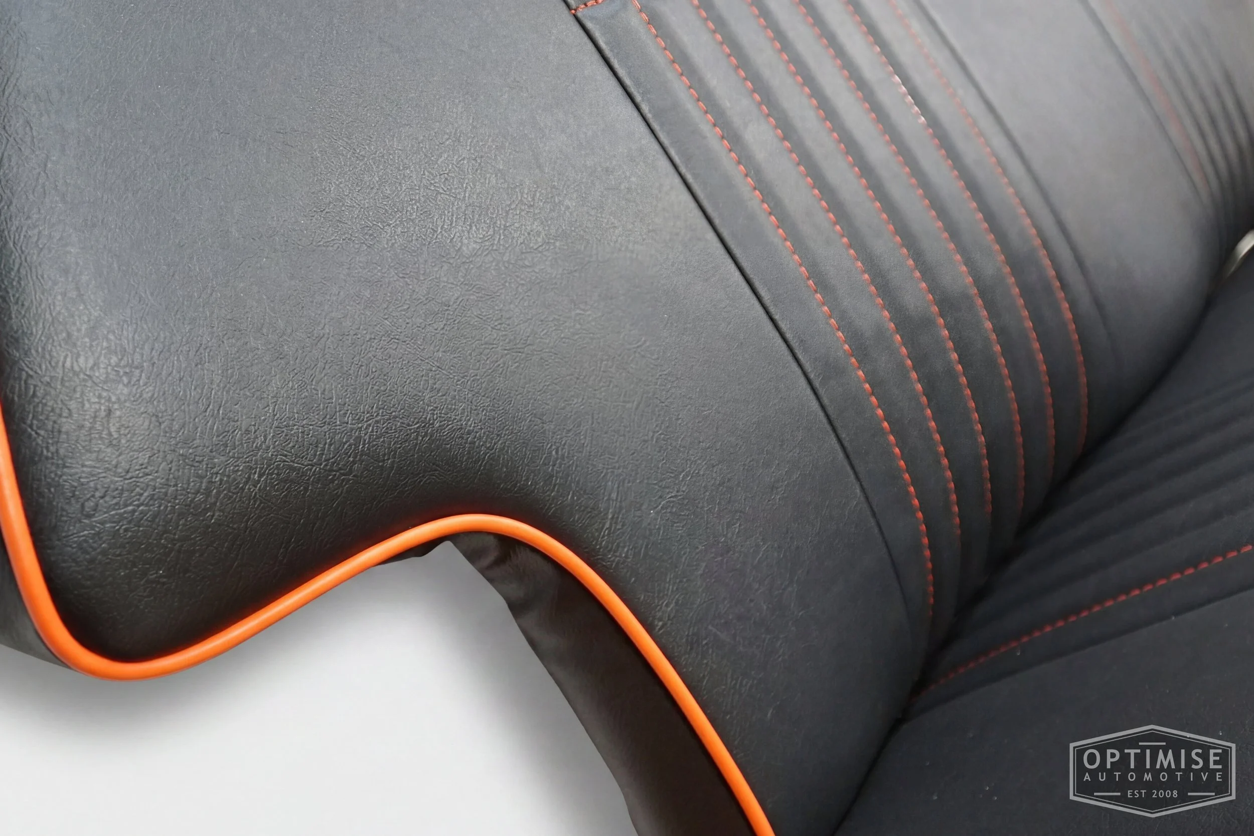 Classic Mini non-reclining seat retrims, trimmed in black leatherette with orange piping and orange stitching.