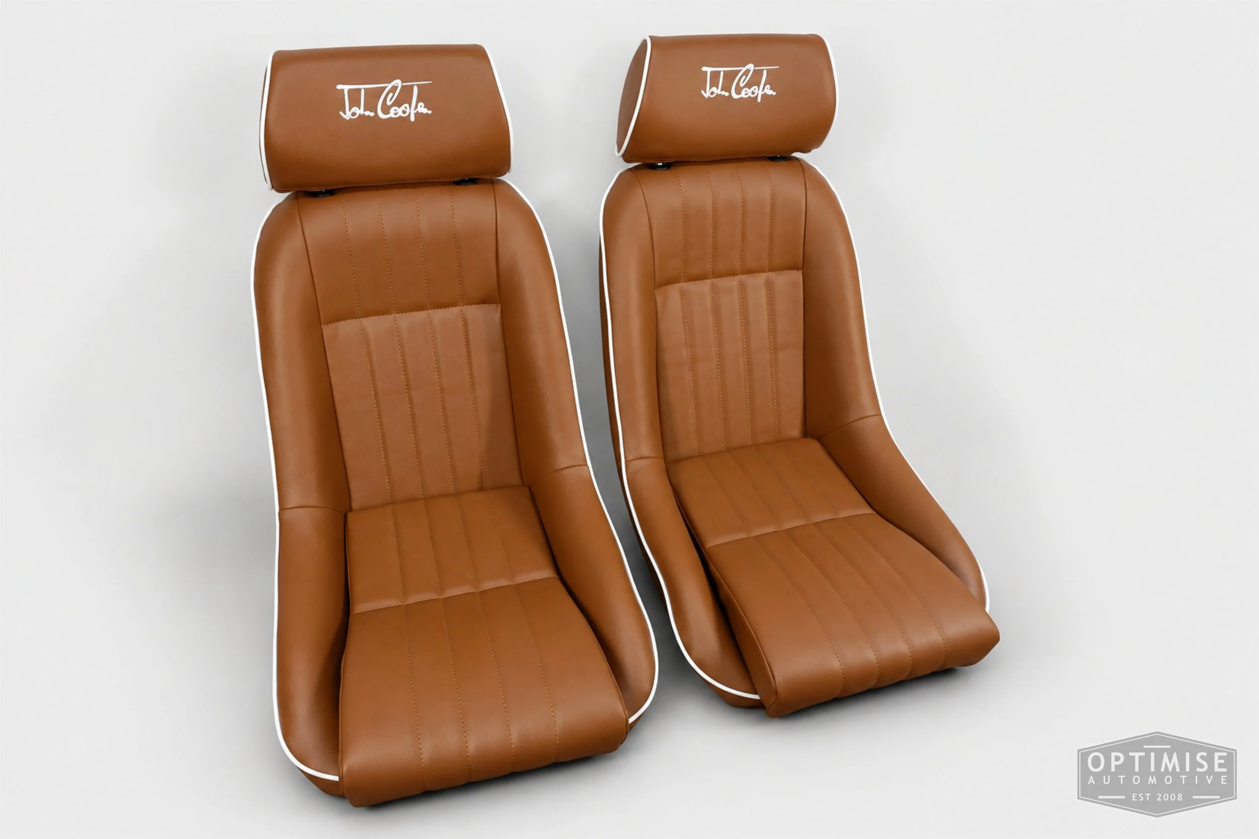 Classic Mini seat retrims featuring Cobra Cub front seats, trimmed in tan leatherette with white piping and John Cooper signature embroidery on the headrests.