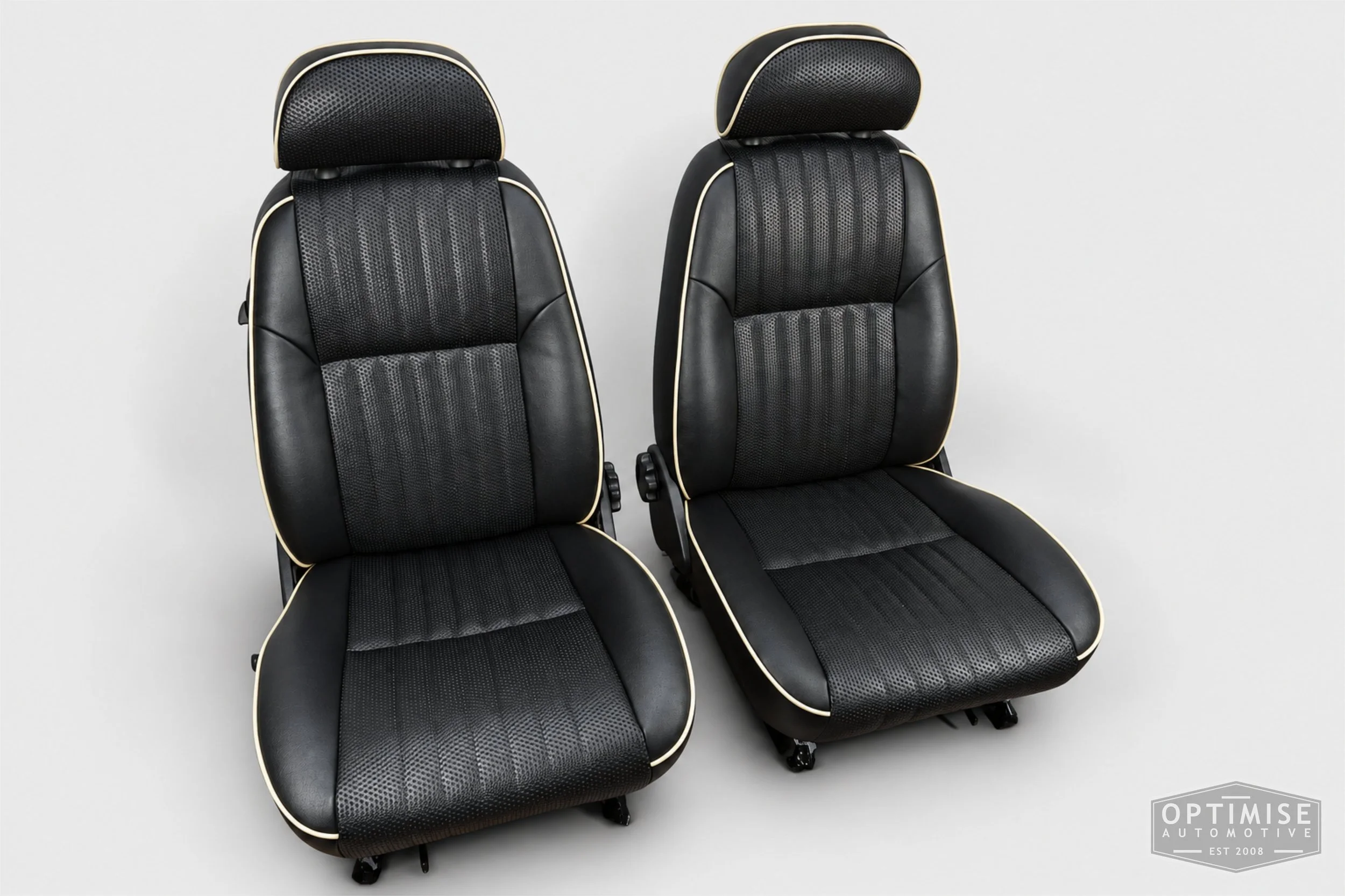 Classic Mini seat retrims featuring original MPi front seats and a matching rear seat, trimmed in black leatherette and black basketweave with cream piping.