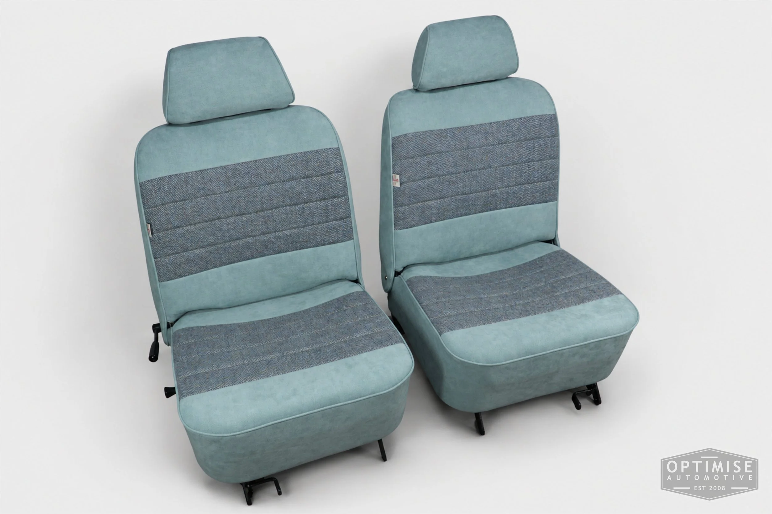 Classic Mini seat retrims featuring original single-post headrest front seats and a matching MK4 rear seat, trimmed in light blue Alcantara and Harris Tweed HB108.