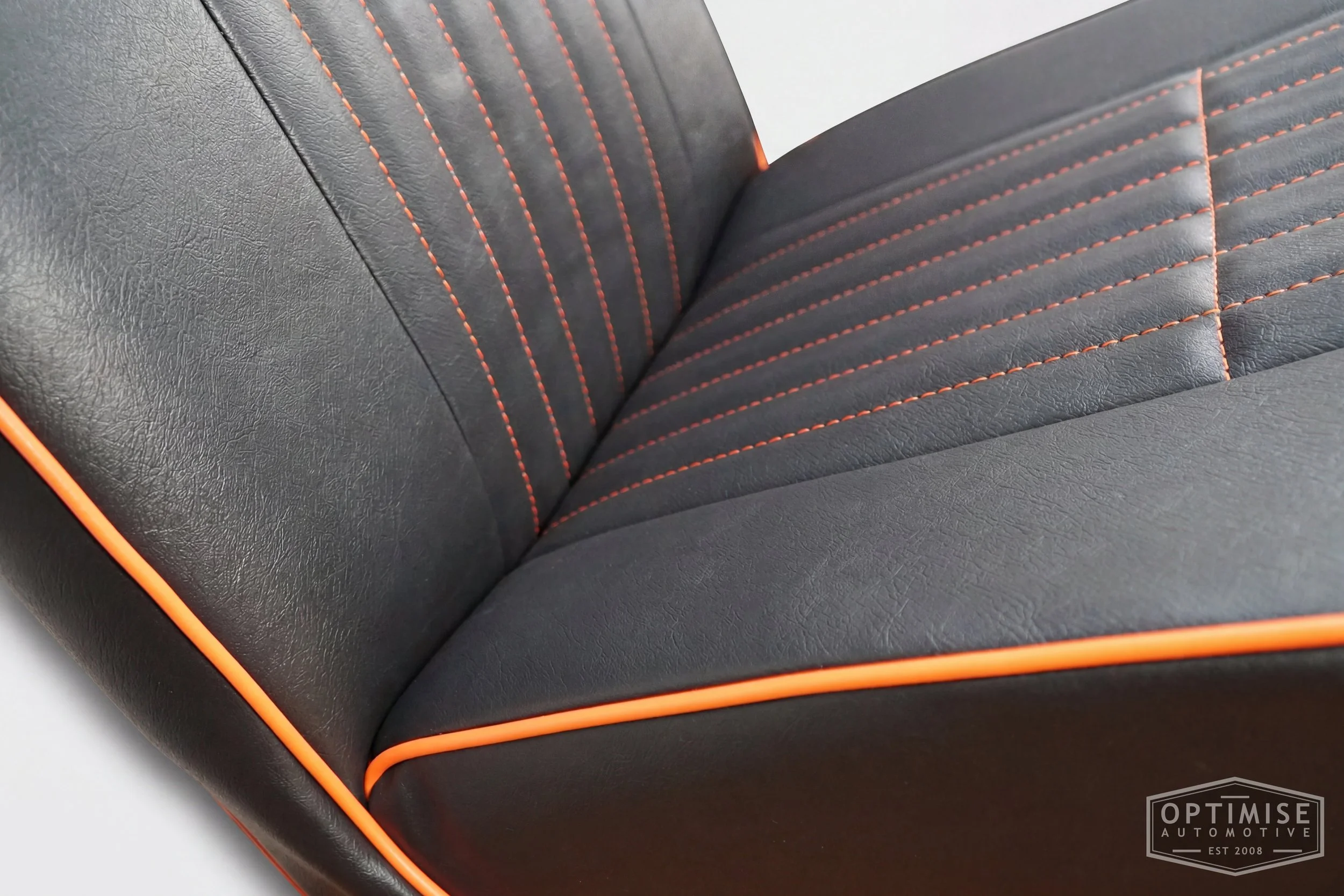 Classic Mini non-reclining seat retrims, trimmed in black leatherette with orange piping and orange stitching.
