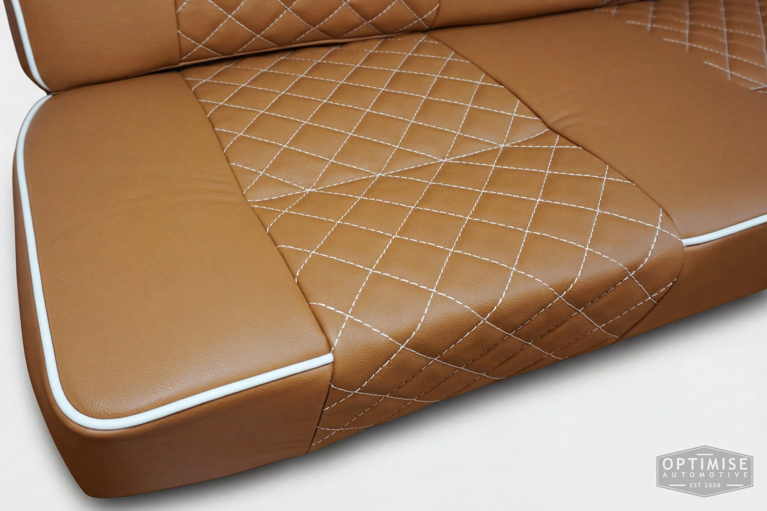 Classic Mini single post headrest seat retrims, trimmed in light brown (tan) leatherette with cream piping and cream diamond stitching.