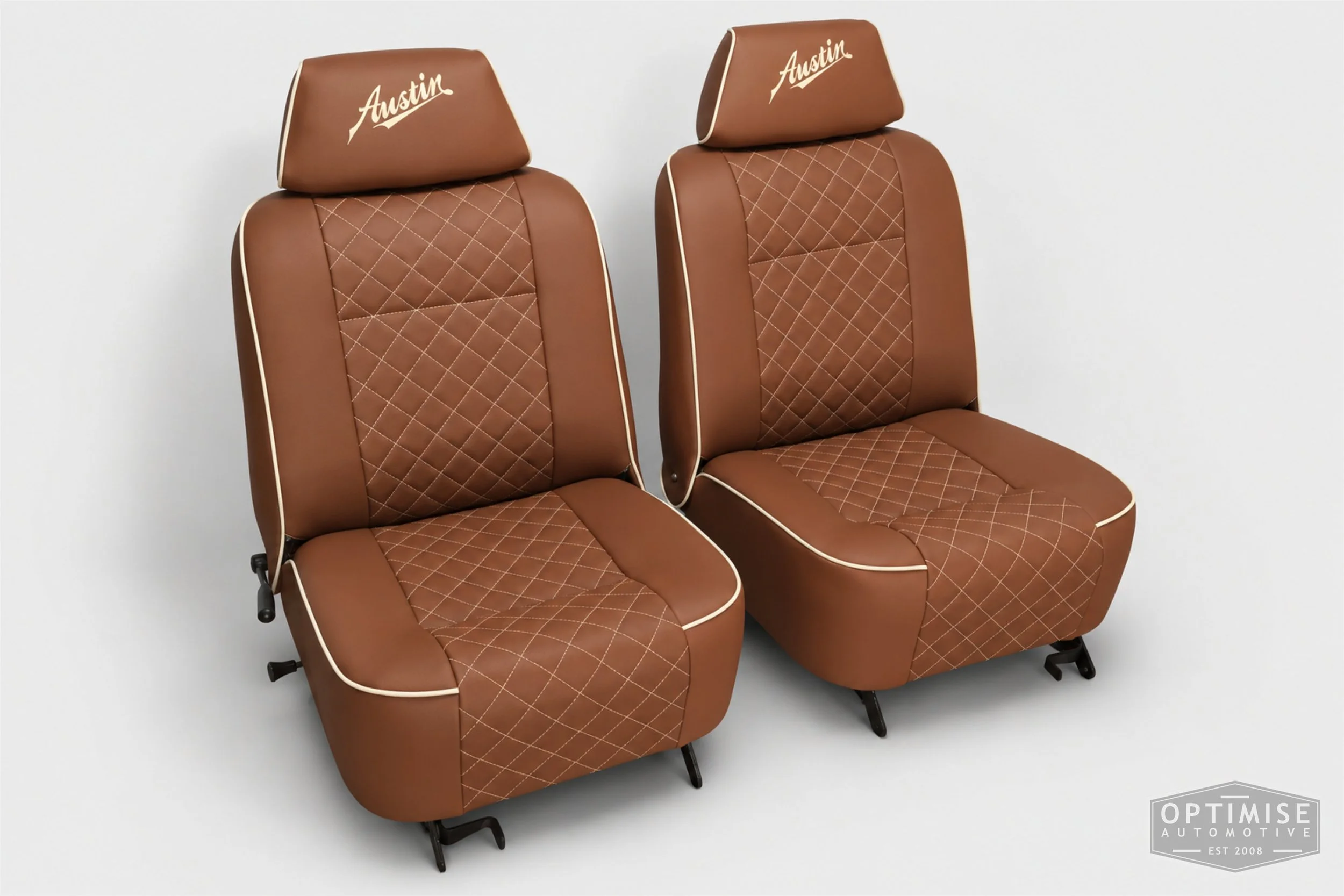 Classic Mini seat retrims featuring original single-post headrest front seats and a matching MK4 rear seat, trimmed in dark tan leatherette with cream diamond stitching and piping, with embroidered headrests.