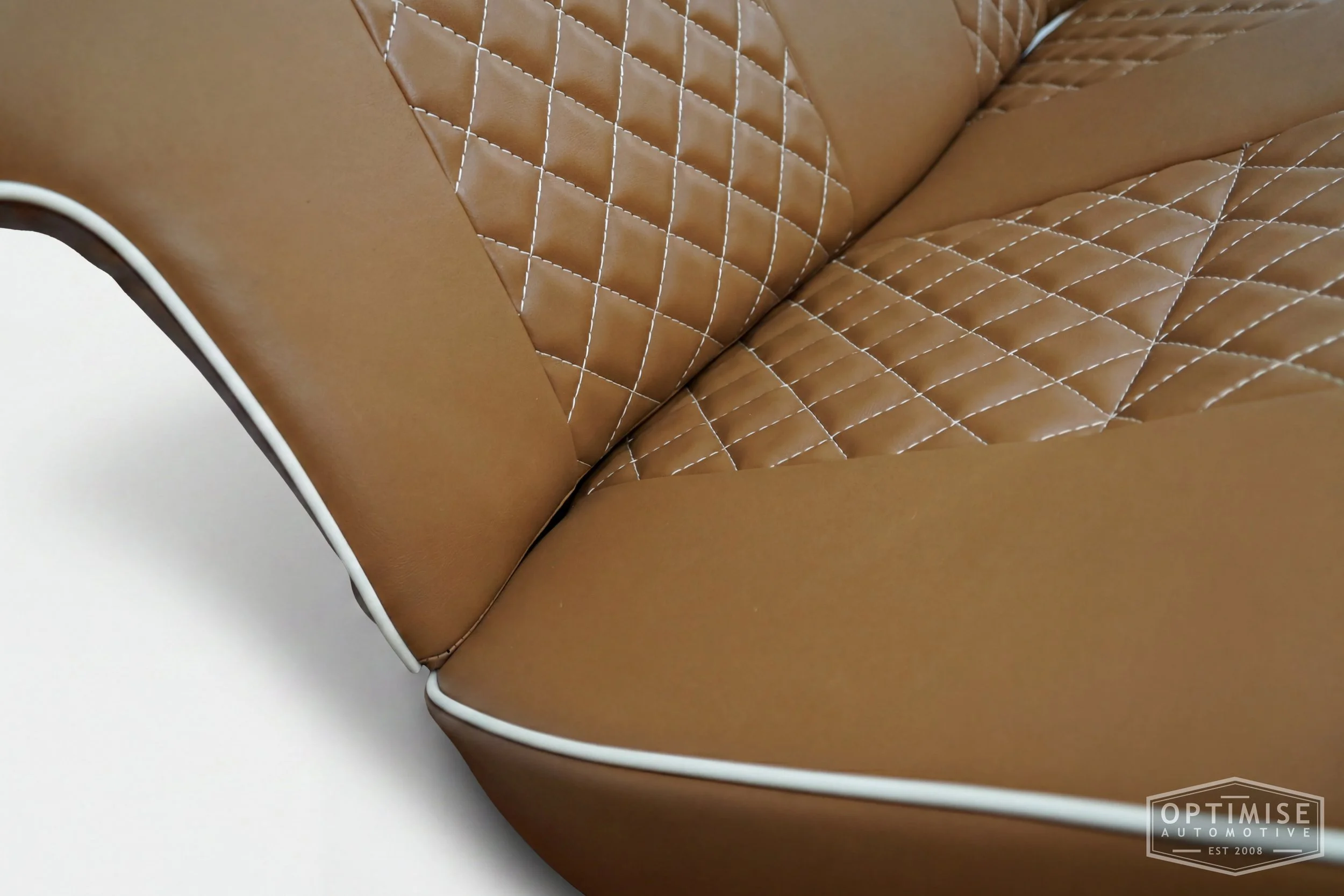 Classic Mini non-reclining seat retrims, trimmed in light brown (tan) leatherette with cream piping and cream diamond stitching.
