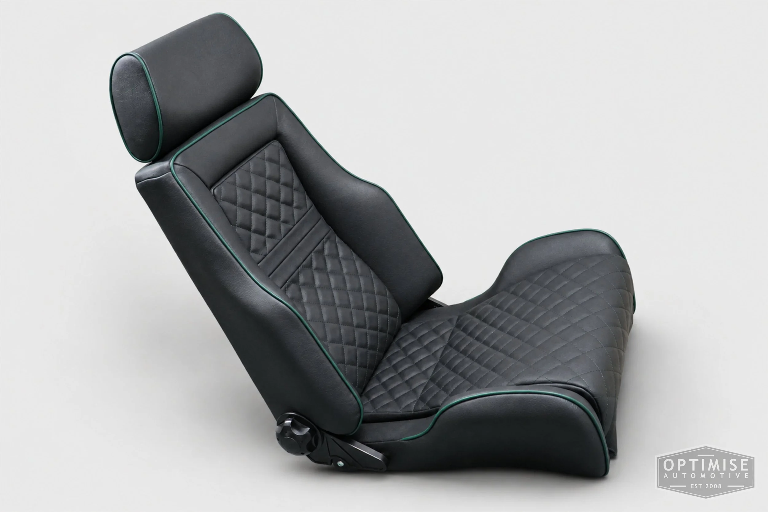 Classic Mini seat retrims featuring Cobra Le Mans front seats and a matching MK5 rear seat, trimmed in black leatherette with British Racing Green diamond stitching and matching green piping.