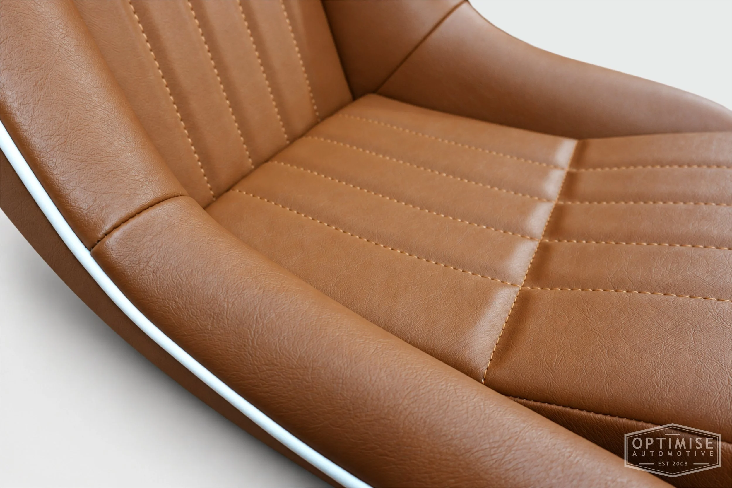 Classic Mini seat retrims featuring Cobra Cub front seats, trimmed in tan leatherette with white piping and John Cooper signature embroidery on the headrests.