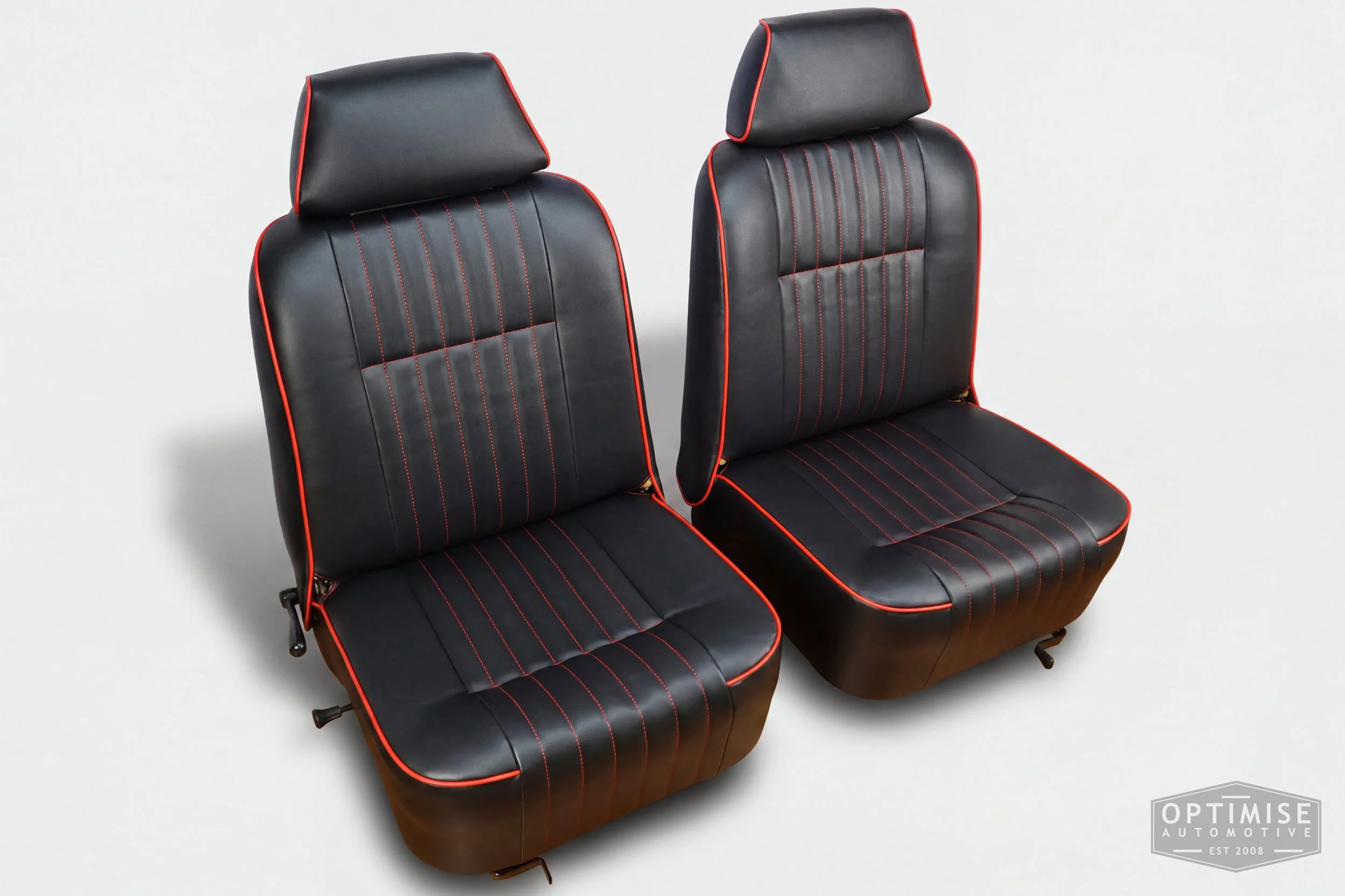 Classic Mini single post headrest seat retrims, trimmed in black leatherette with red piping and stitching.