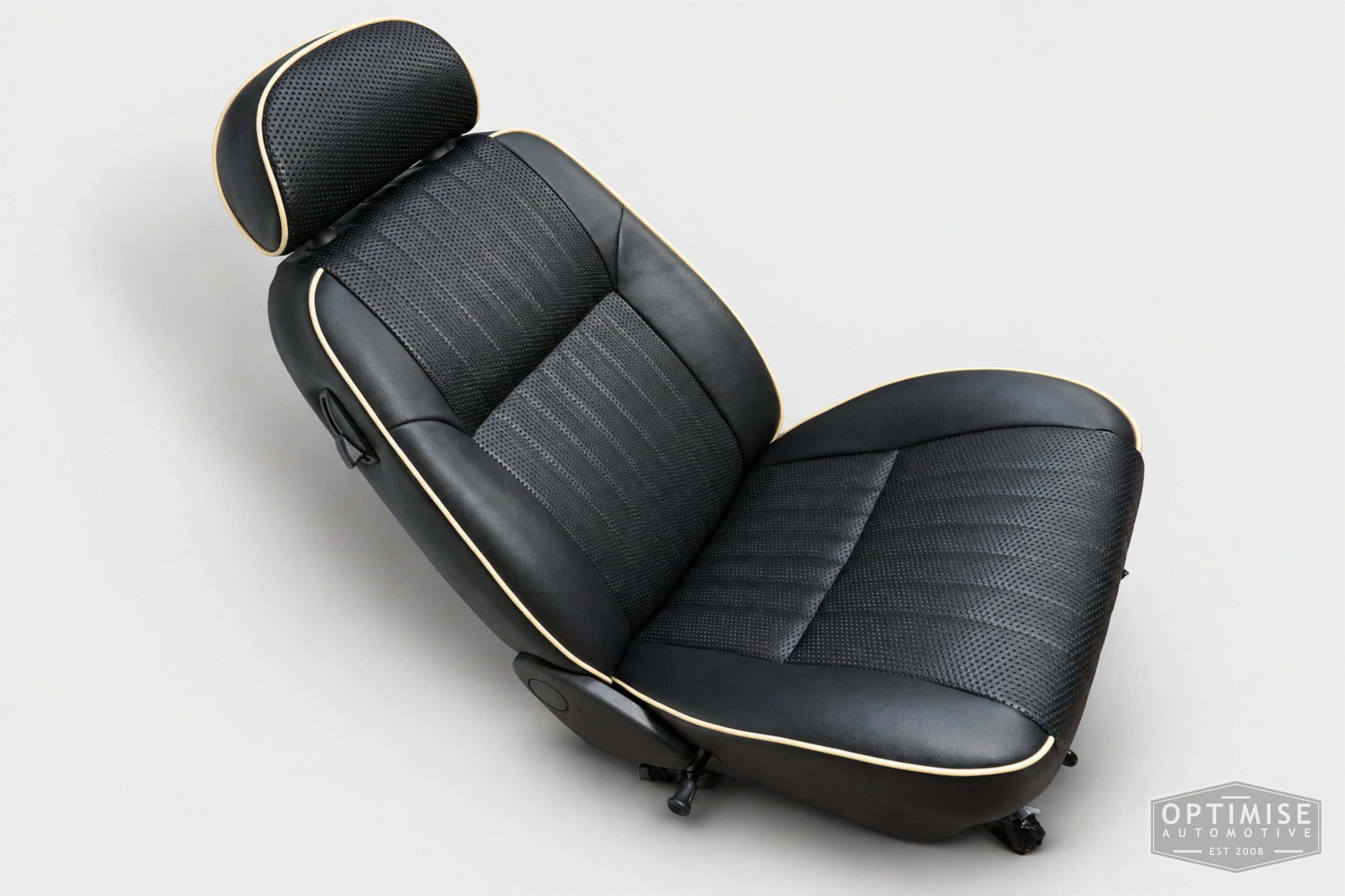 Classic Mini seat retrims featuring original MPi front seats and a matching rear seat, trimmed in black leatherette and black basketweave with cream piping.