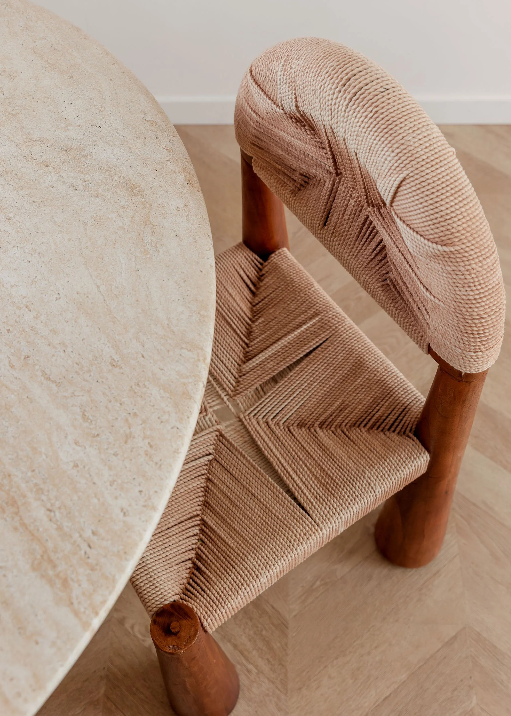 Woven chair detail with natural fibers and stone tabletop