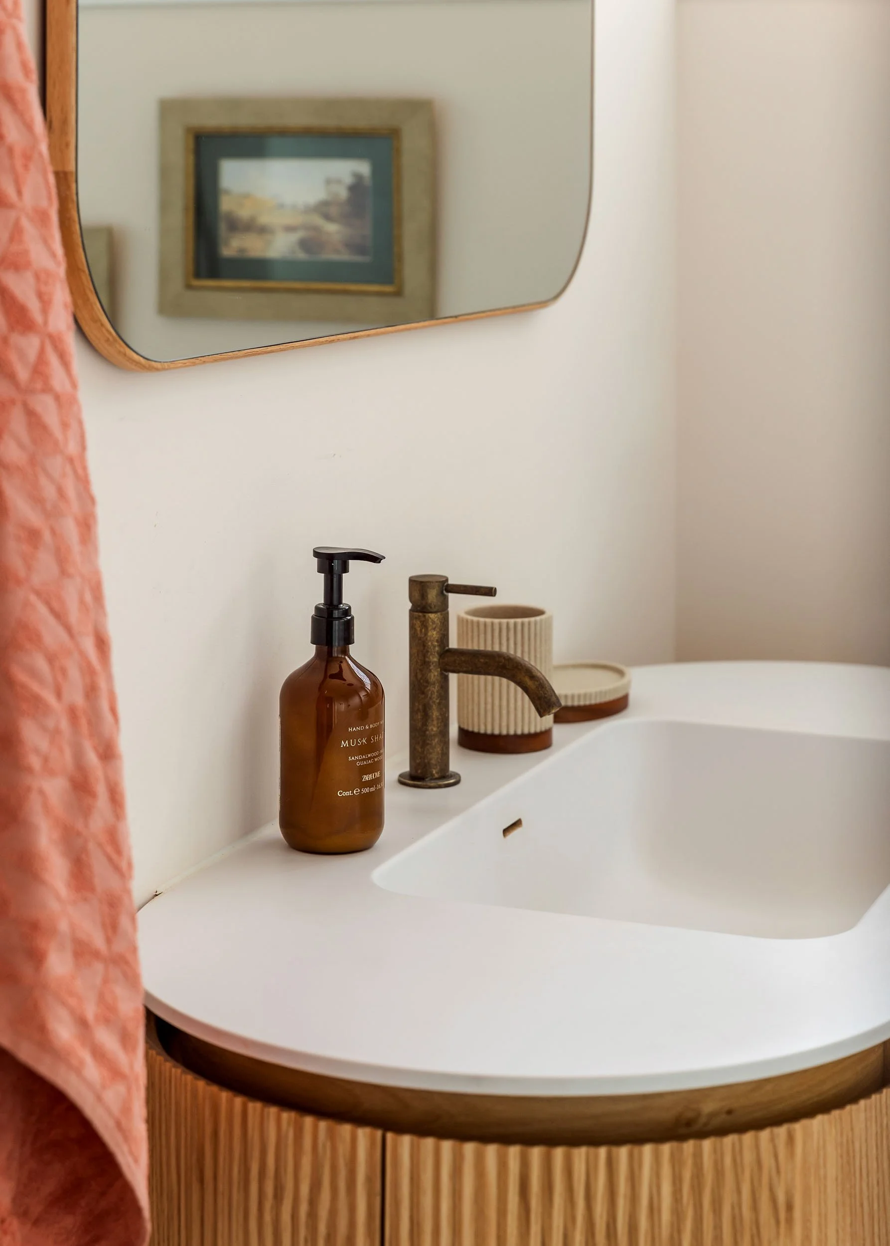 Bathroom sink detail with brass fixtures and soft finishes