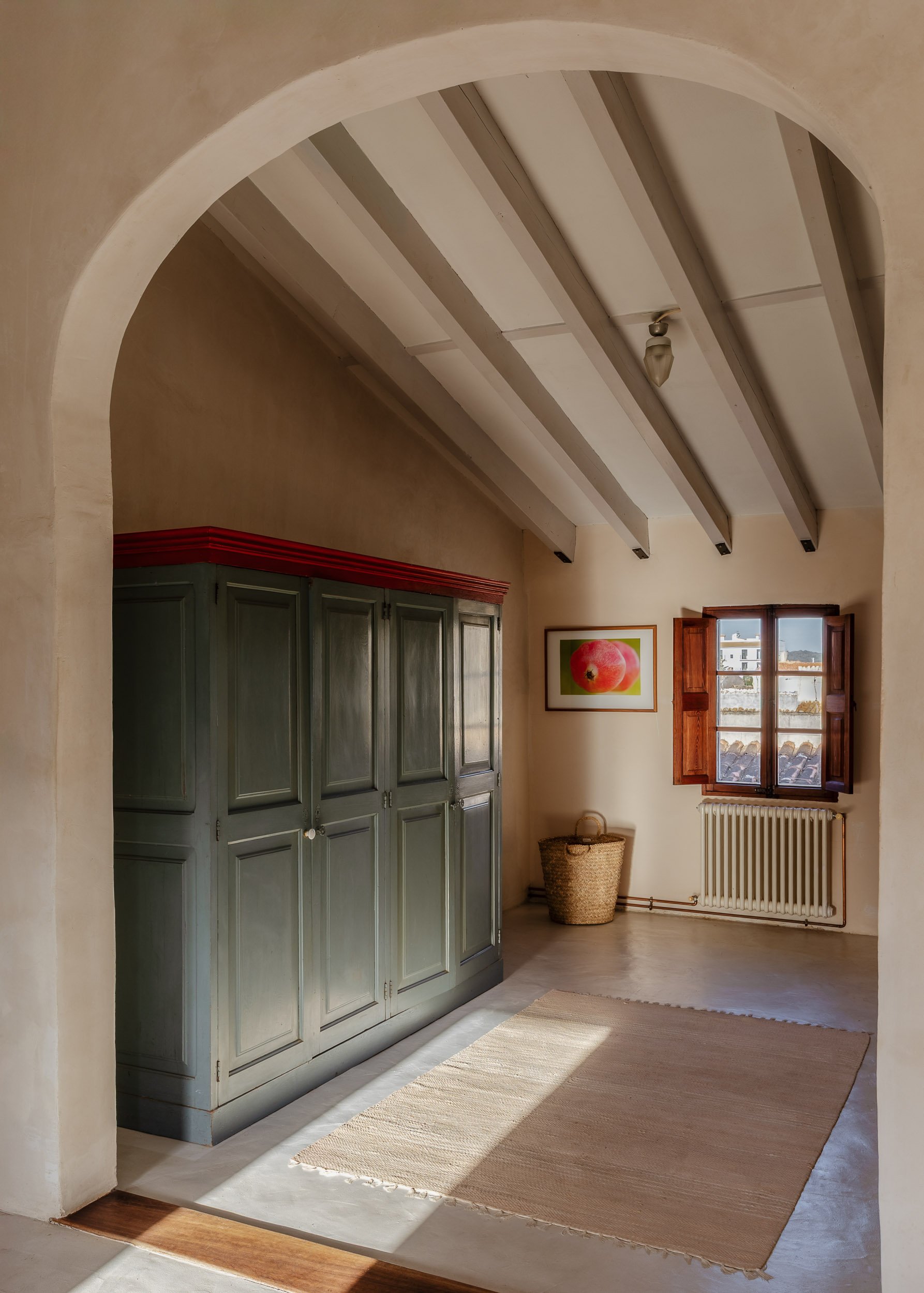 Arched interior space with vintage wardrobe and exposed beams