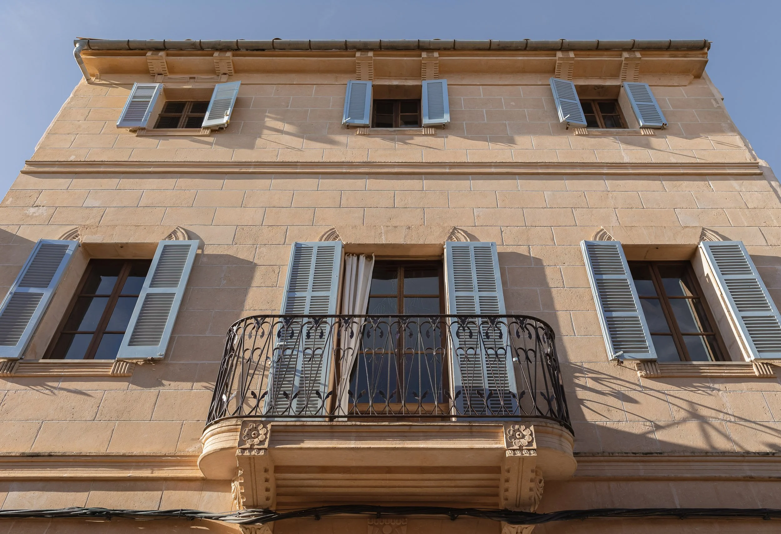 Historic Mediterranean facade with blue shutters and wrought-iron balcony