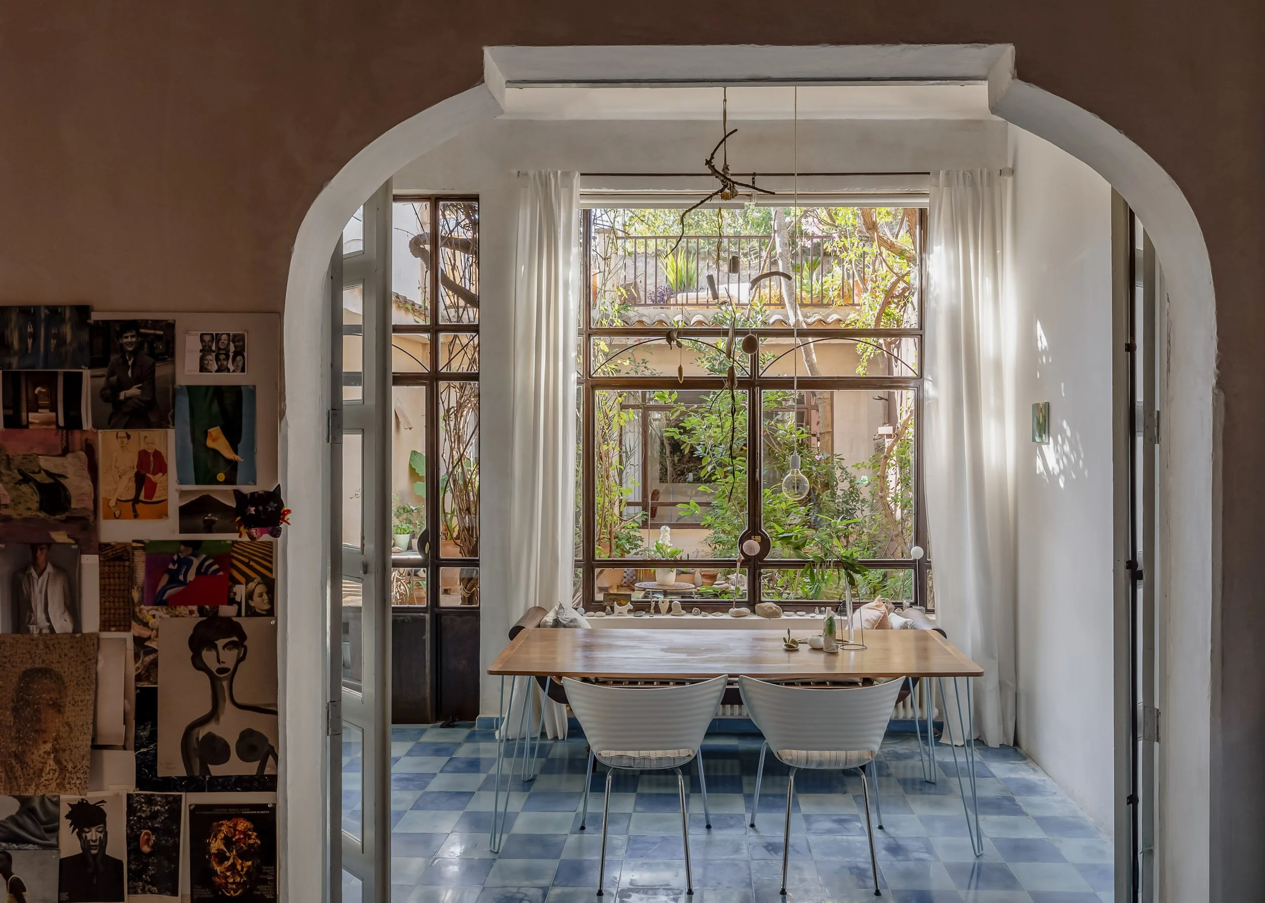 Bright dining space with arched windows and blue tiled floor