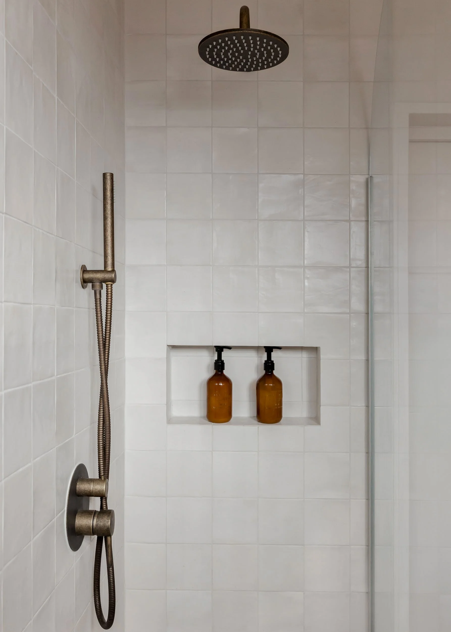 Walk-in shower with white tiles and built-in niche