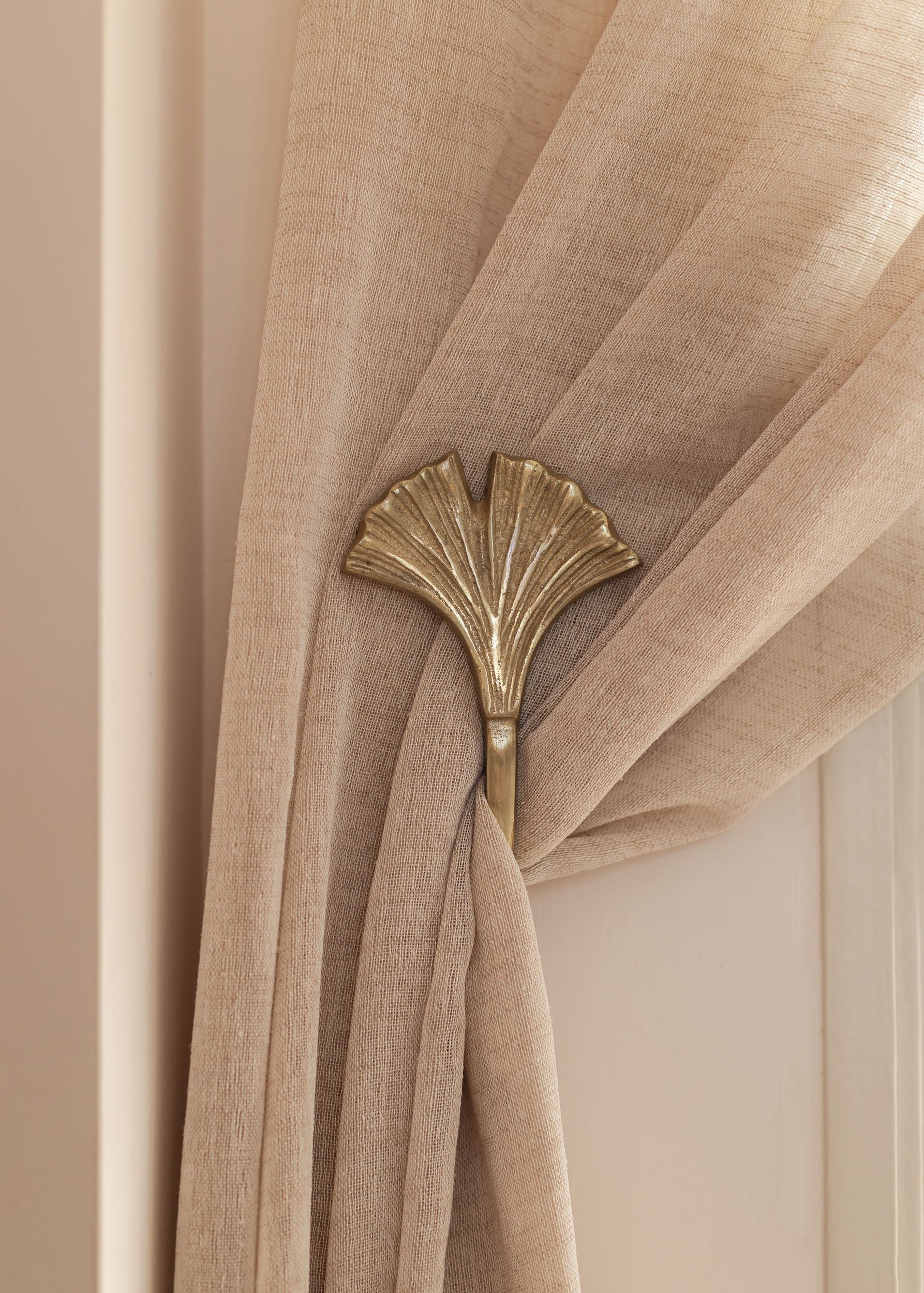 Curtain detail with decorative tieback and textured fabric