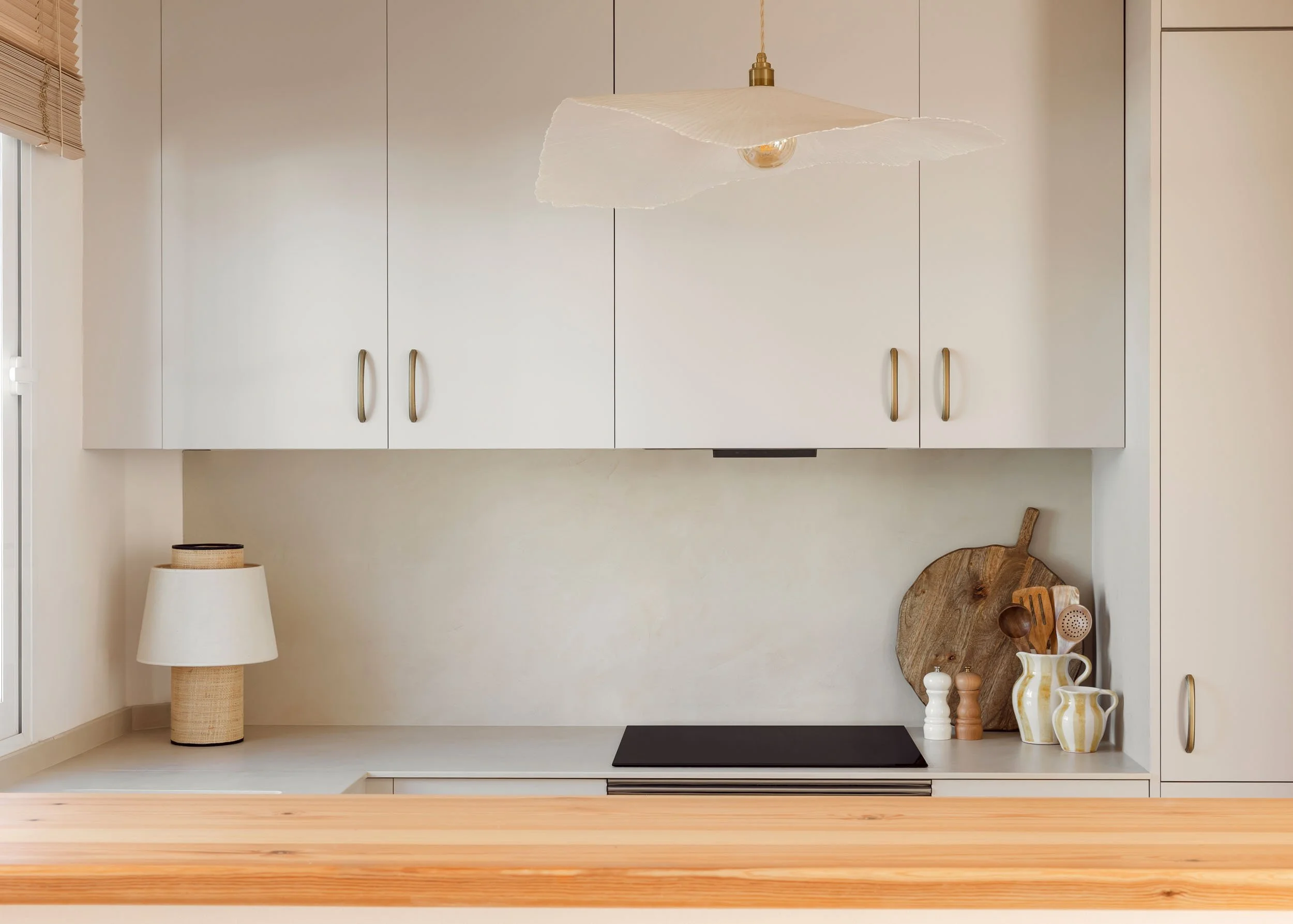 Minimal kitchen with light cabinetry and wooden countertop