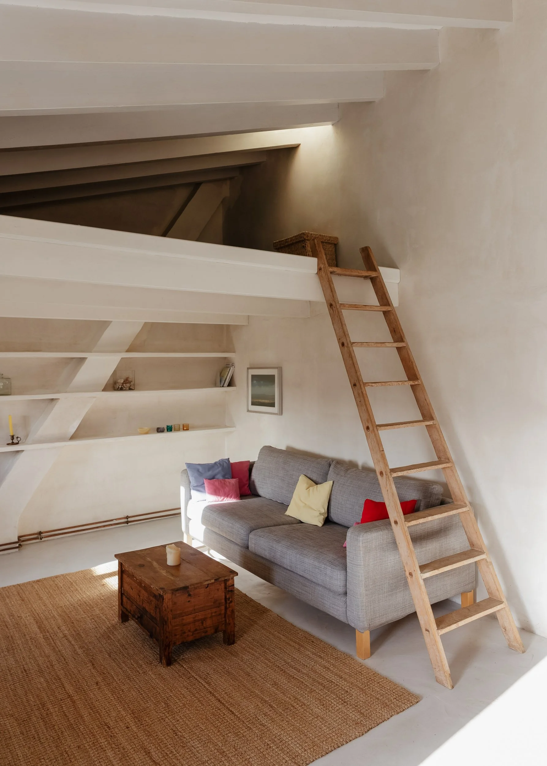 Loft-style living area with wooden ladder and textured finishes