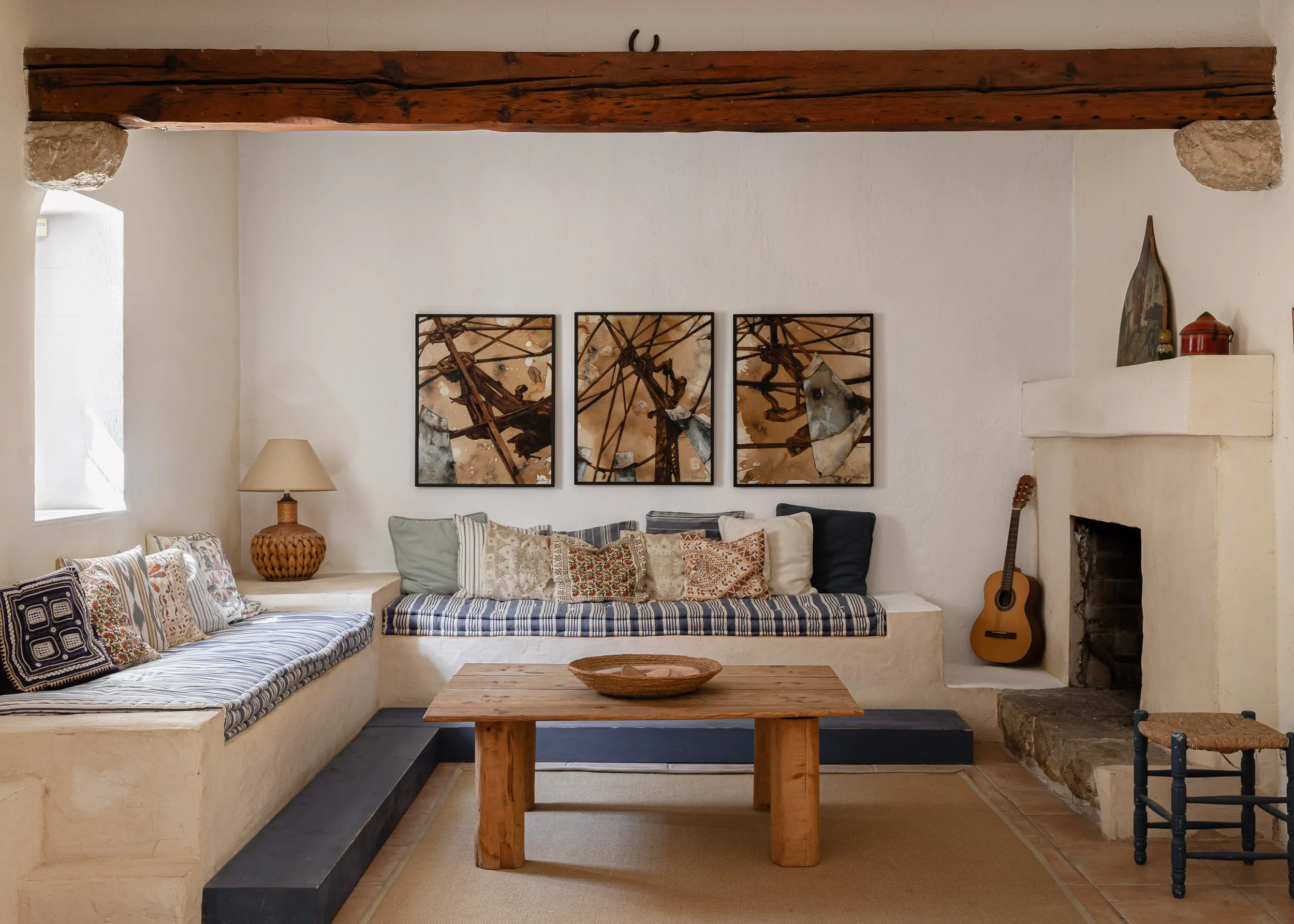 Mallorcan living room design with built in masonry seating and soft indigo textile accents.