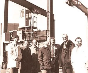 Photo containing the original founders of WISE from 1976 standing in front of one of the first WISE boat hoists made