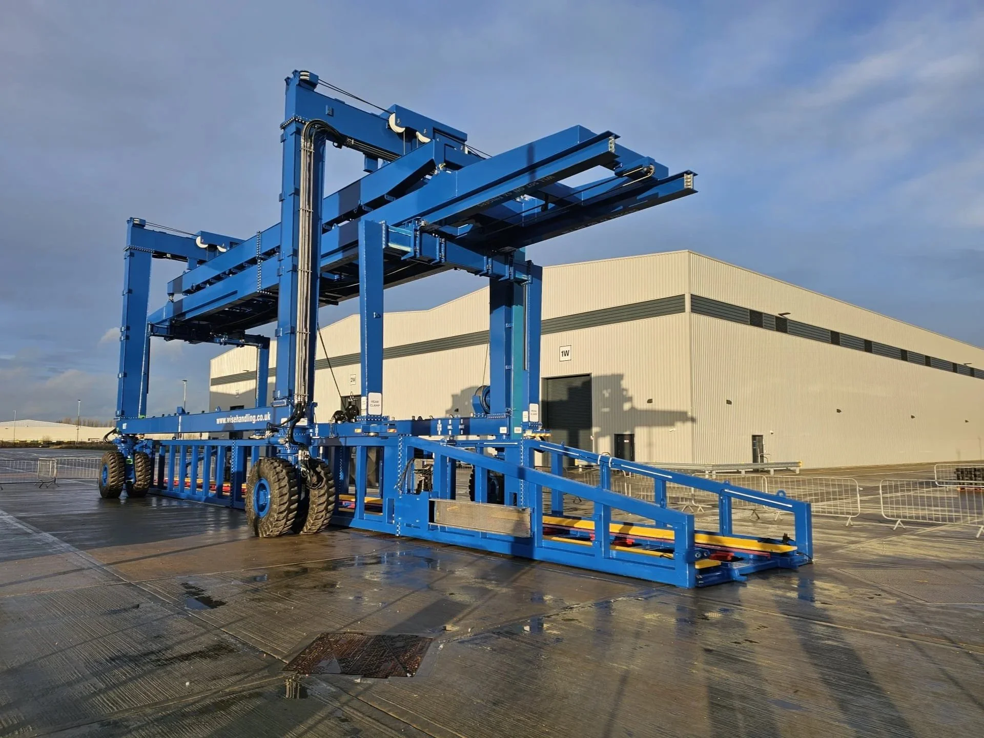 Large blue bespoke industrial hoist for offloading, loading and moving train carriages, car bodies and containers around a factory complex