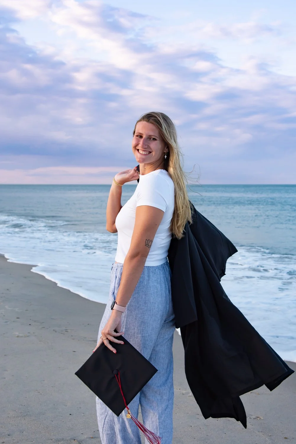 Sunset college graduation portraits captured by Rayne Photography on the beach at Rehoboth Beach