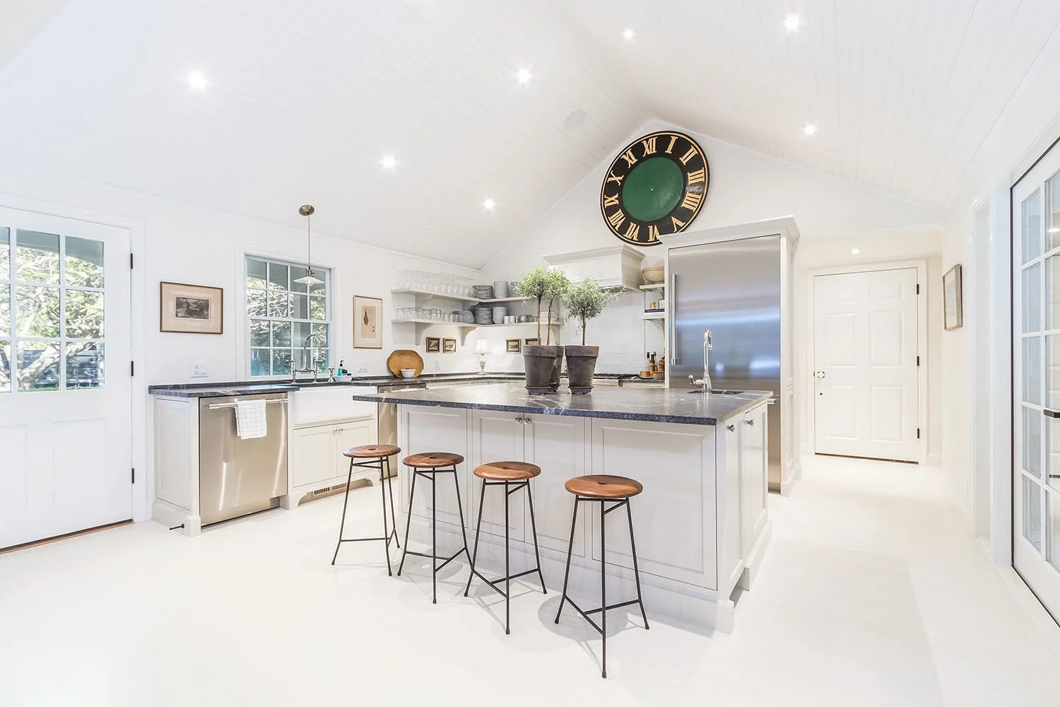 Bright custom coastal home kitchen with vaulted paneled ceilings, island seating, and refined Cape Cod craftsmanship.