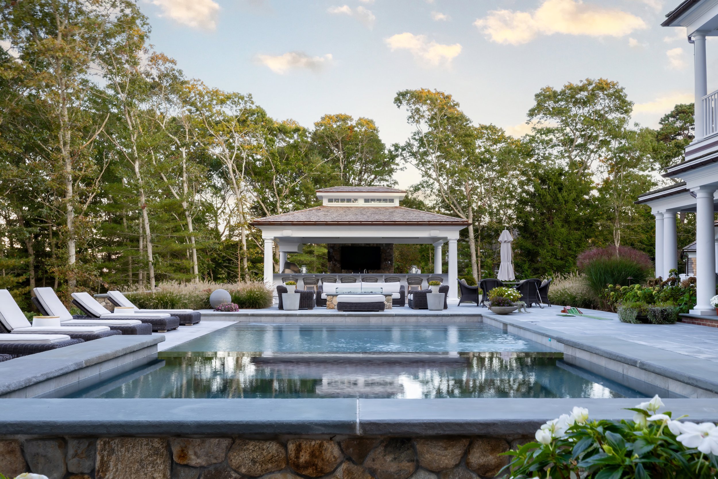 Custom backyard oasis by Sea View Builders featuring a luxury pool, spa, pool house, outdoor kitchen, and Cape Cod landscape design.