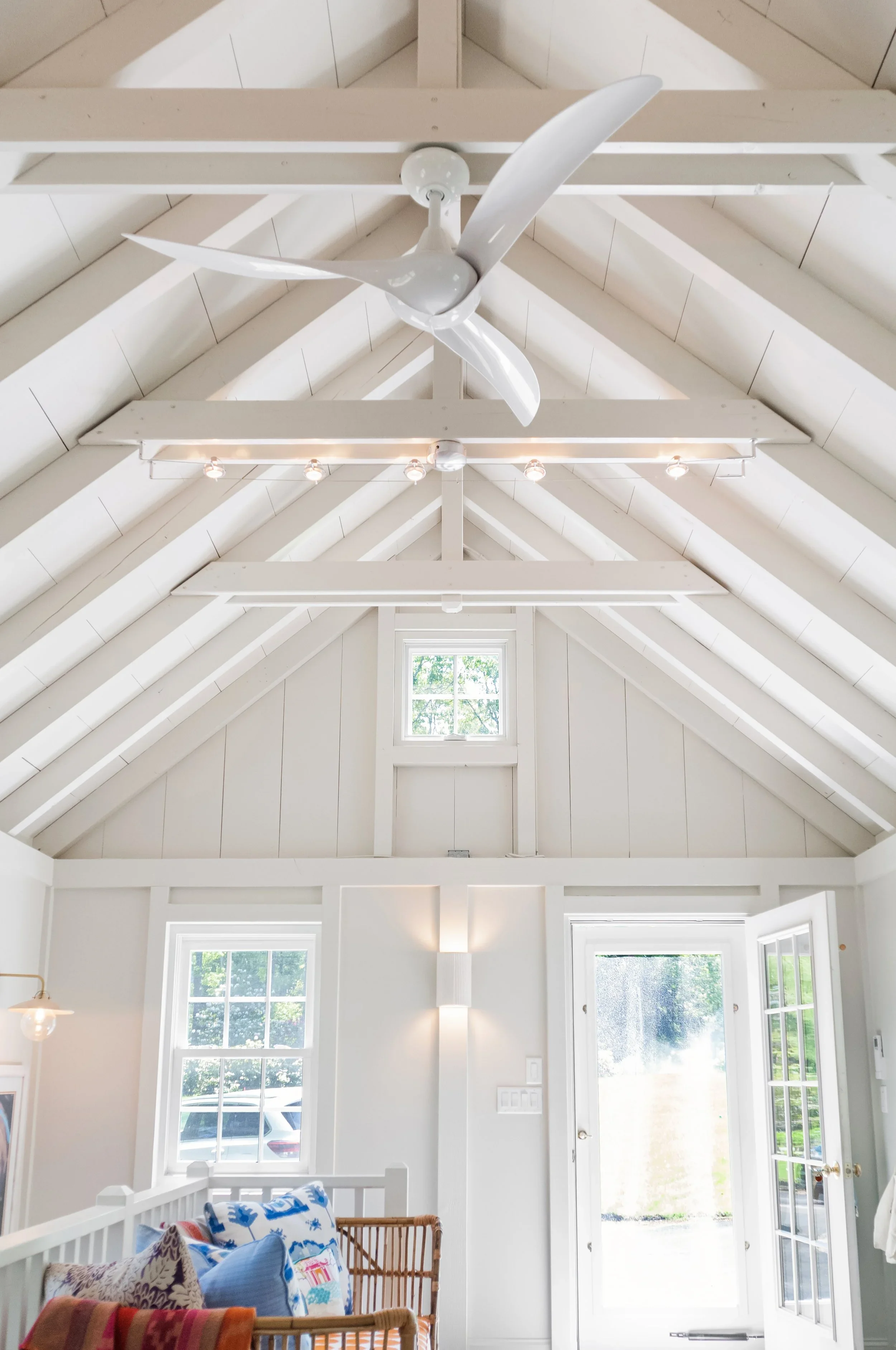 Custom timber trusses, vaulted ceilings, and natural light highlight this Cape Cod pool house designed by Sea View Builders.