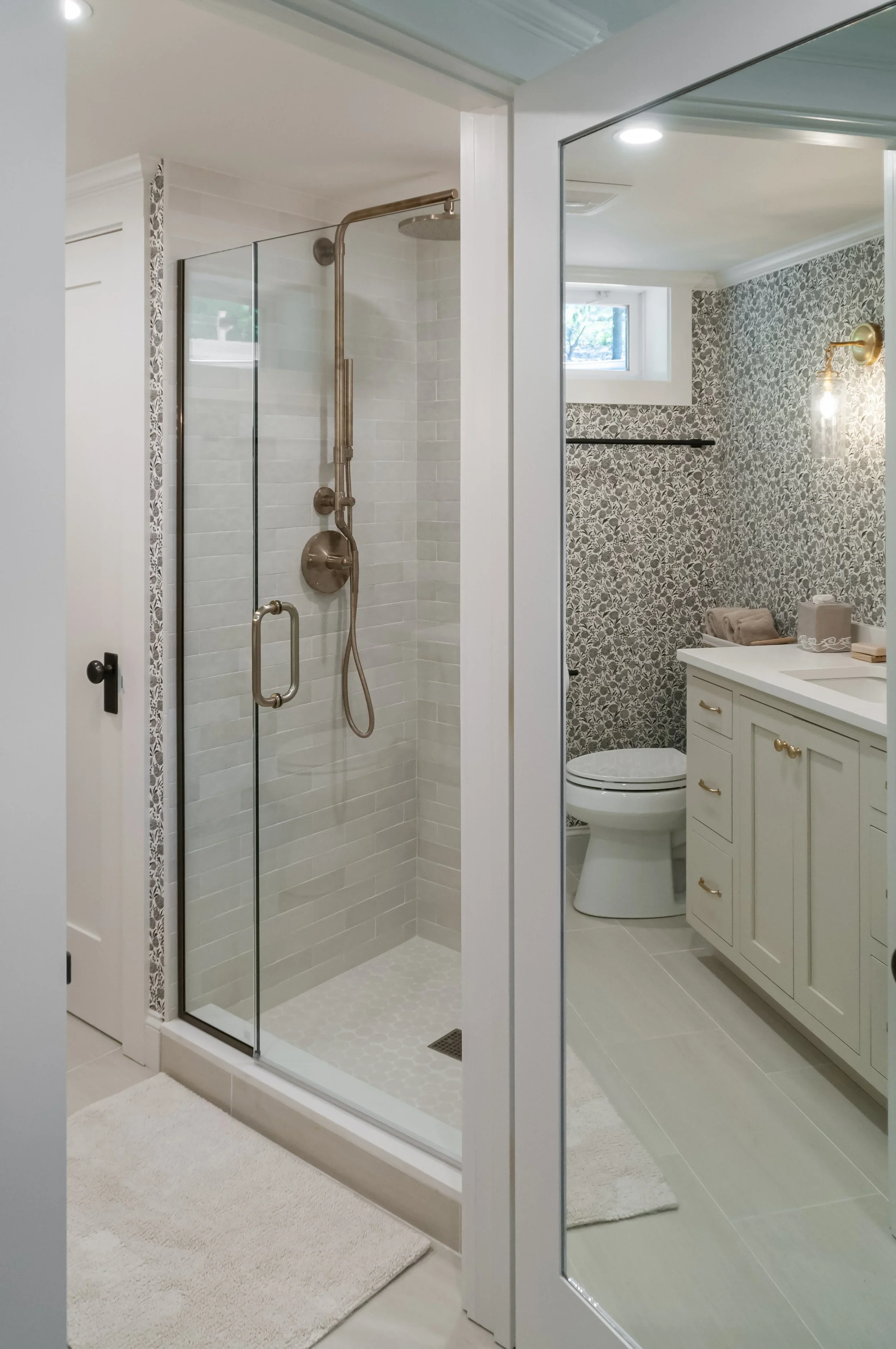 Custom bathroom by Sea View Builders featuring a walk-in glass shower, custom cabinetry, quartz countertop, brass fixtures, and Cape Cod coastal design.