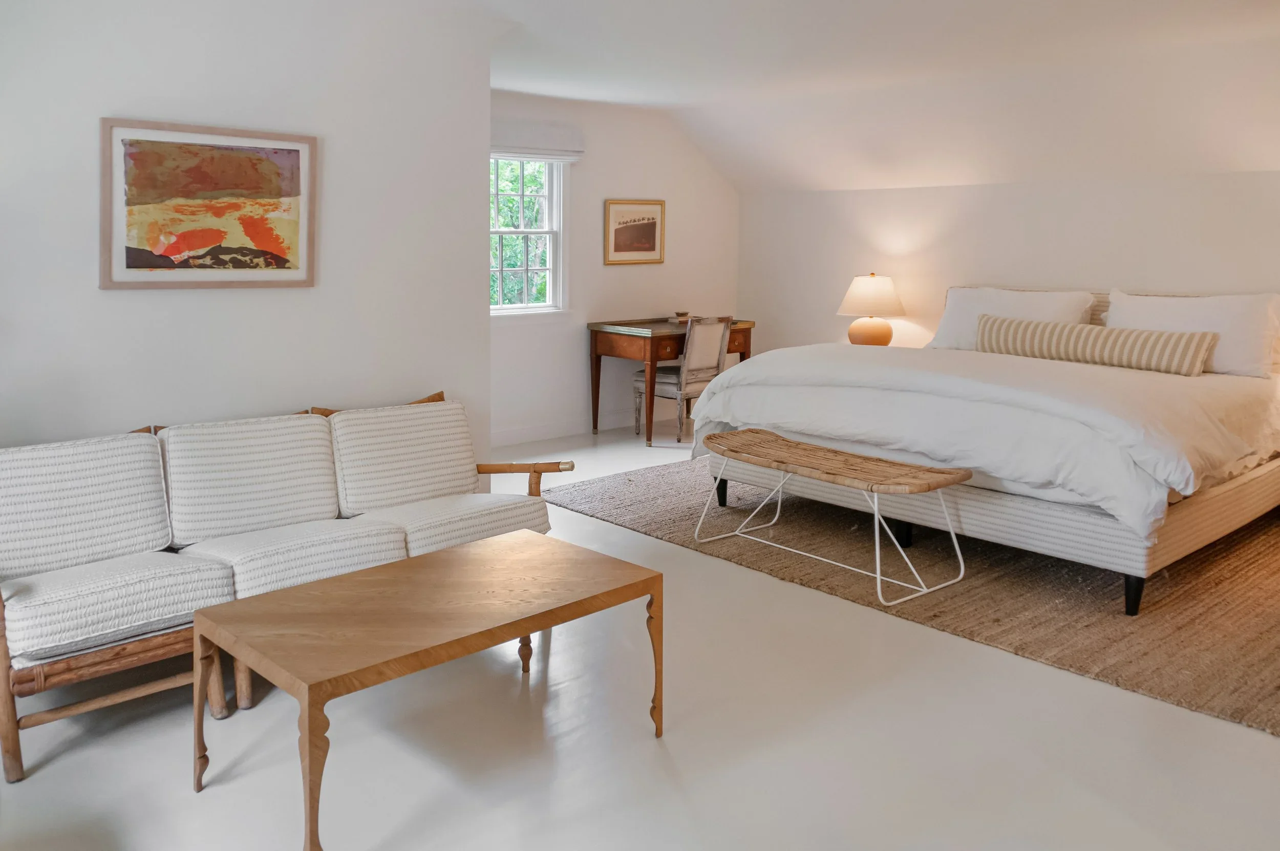 Sea View Builders designed this custom Cape Cod bedroom suite with a sitting area, workspace, vaulted ceilings, and bright coastal interior design.