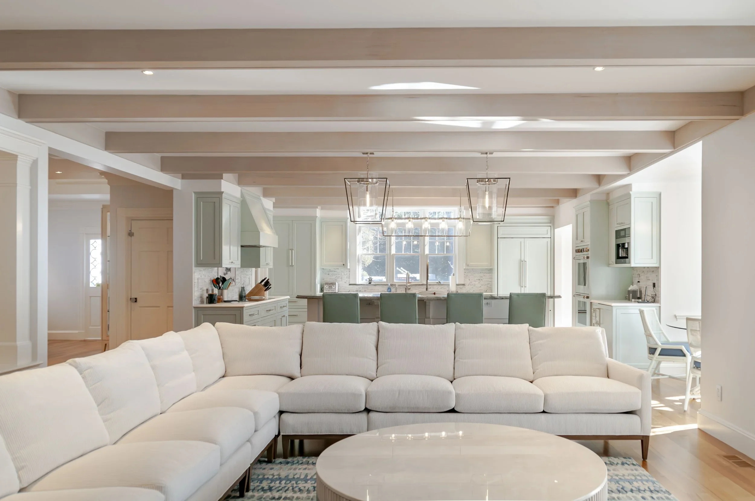 From the living room to the kitchen, this Sea View Builders home showcases exposed beams, custom cabinetry, a spacious island, and timeless Cape Cod coastal design.