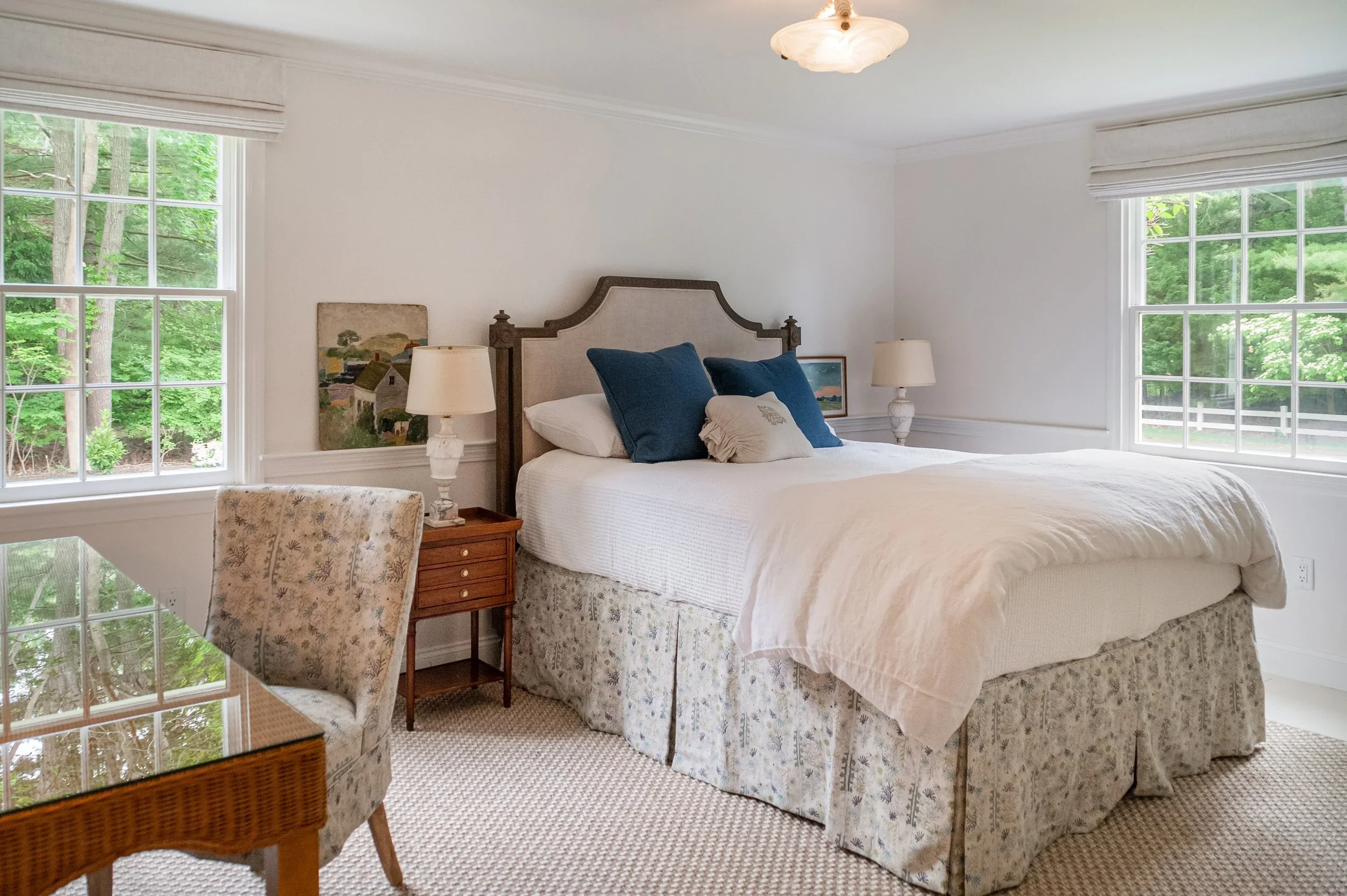 Cape Cod primary bedroom with oversized windows, custom trim, neutral finishes, and abundant natural light.