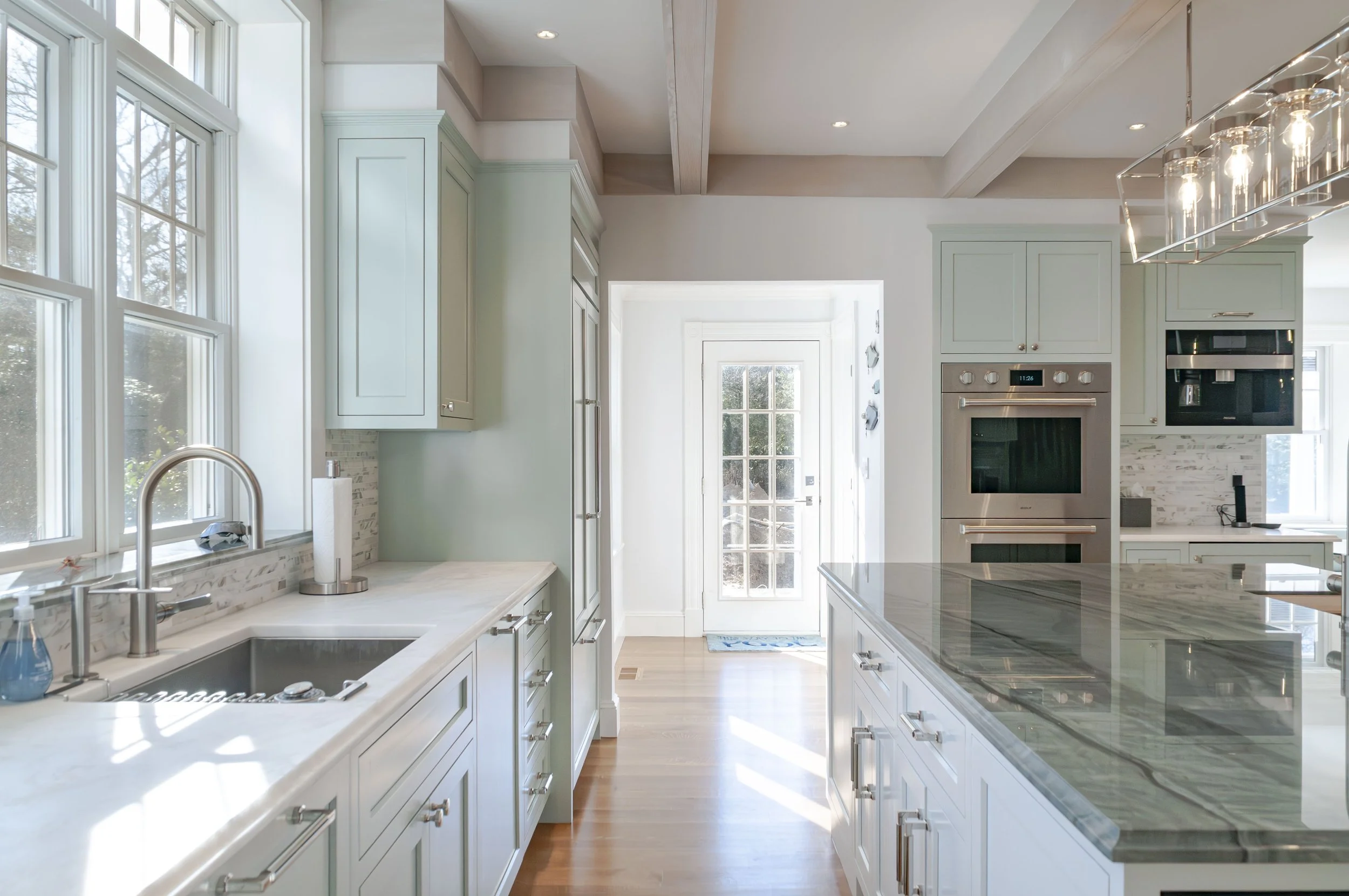 Custom Coastal Home with expansive windows, lower level doors, and a lush Cape Cod Lawn