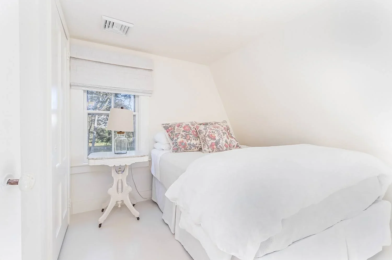 Sea View Builders designed this Cape Cod guest bedroom with a dormer window, custom millwork, and a bright, inviting retreat.